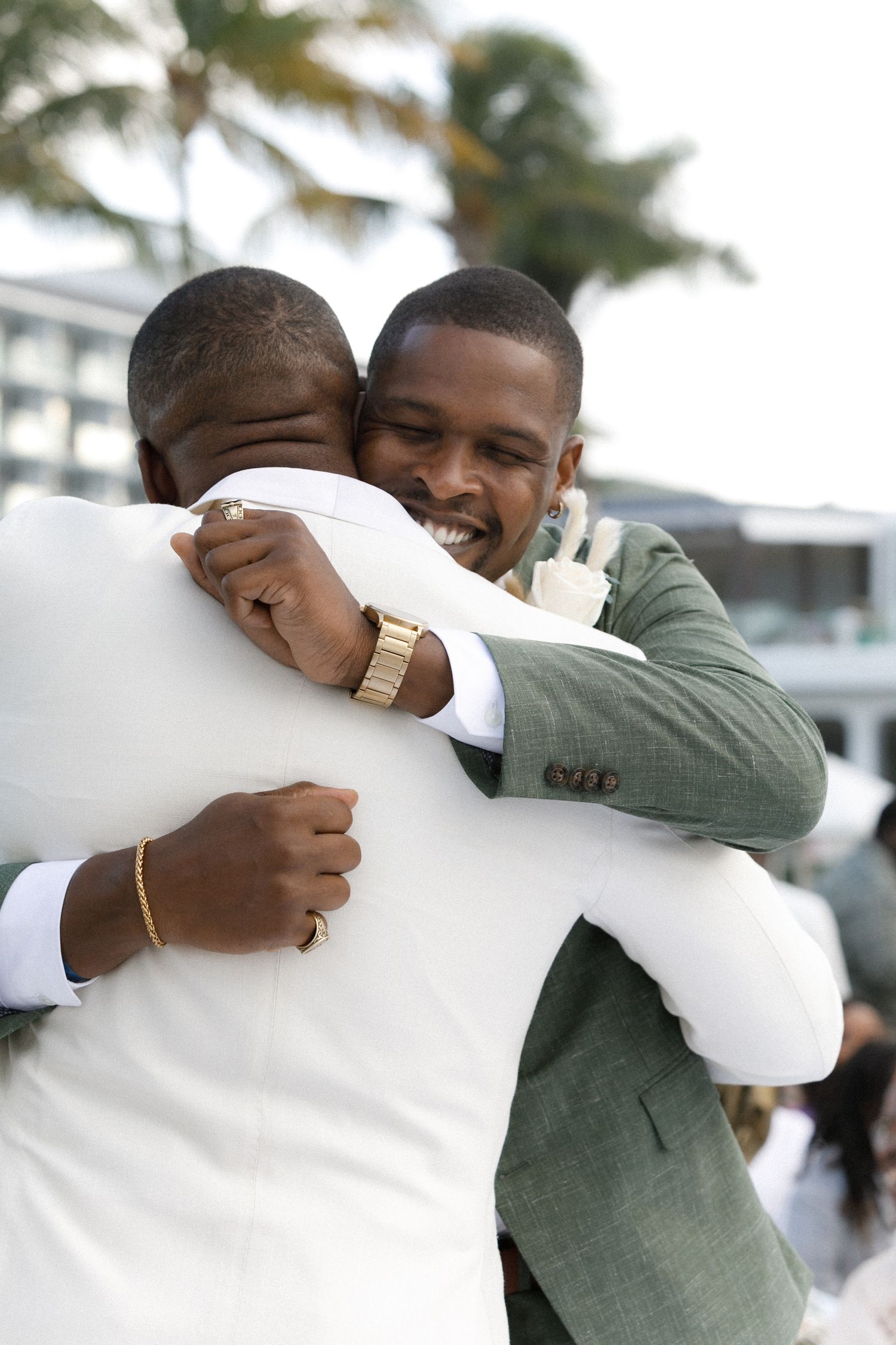 Two people share a joyful embrace during an outdoor celebration.