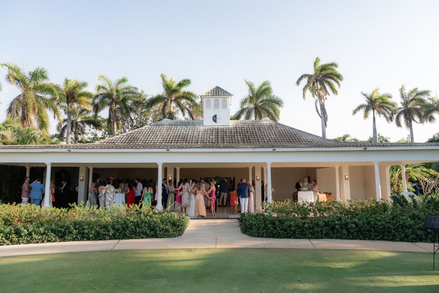 Elegant white colonial-style wedding venue with palm trees and manicured grounds.