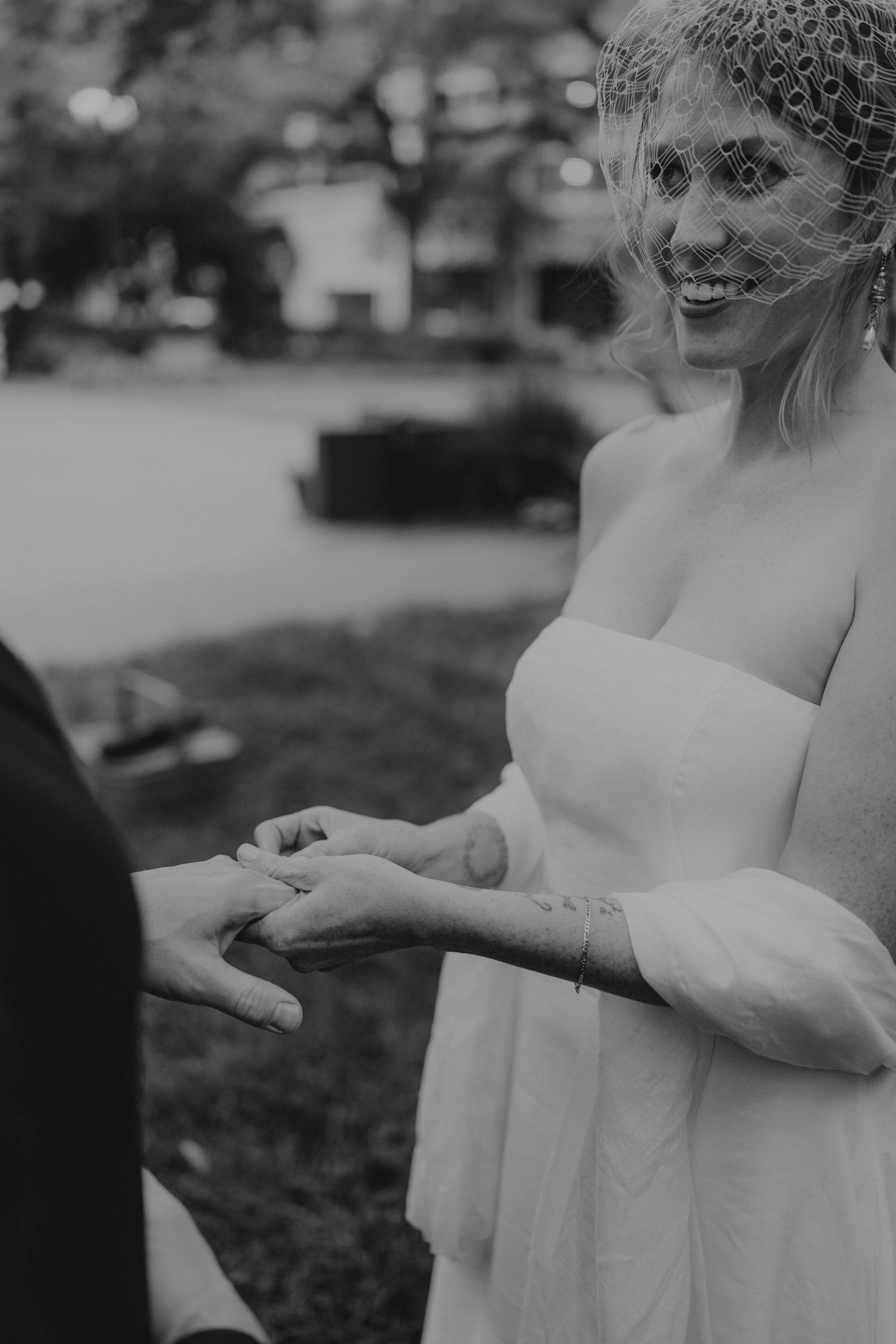 A series of black and white photos showing hands releasing a butterfly in a garden setting.