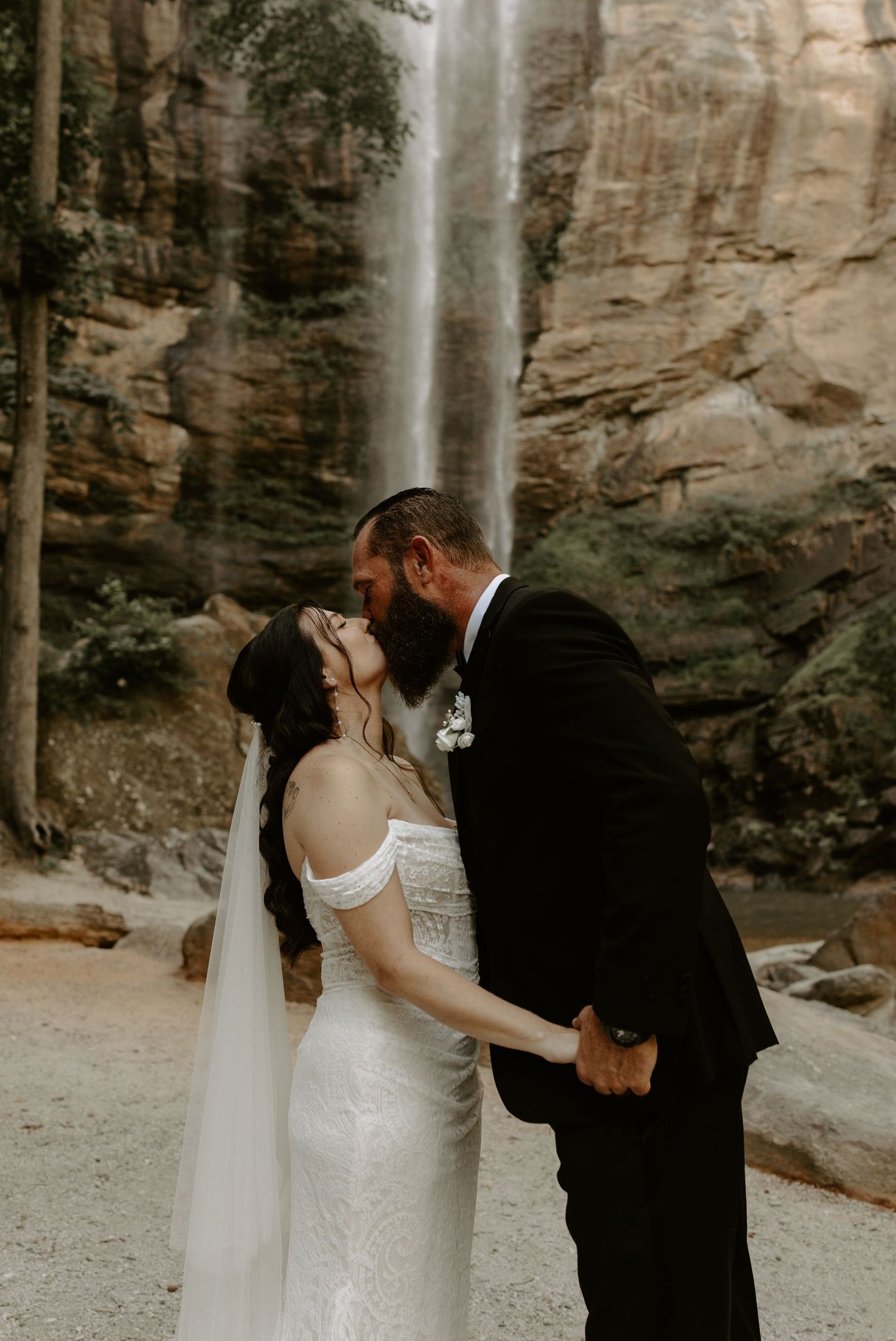 Emotional wedding ceremony at Toccoa Falls, Georgia with the cascading waterfall as a backdrop.