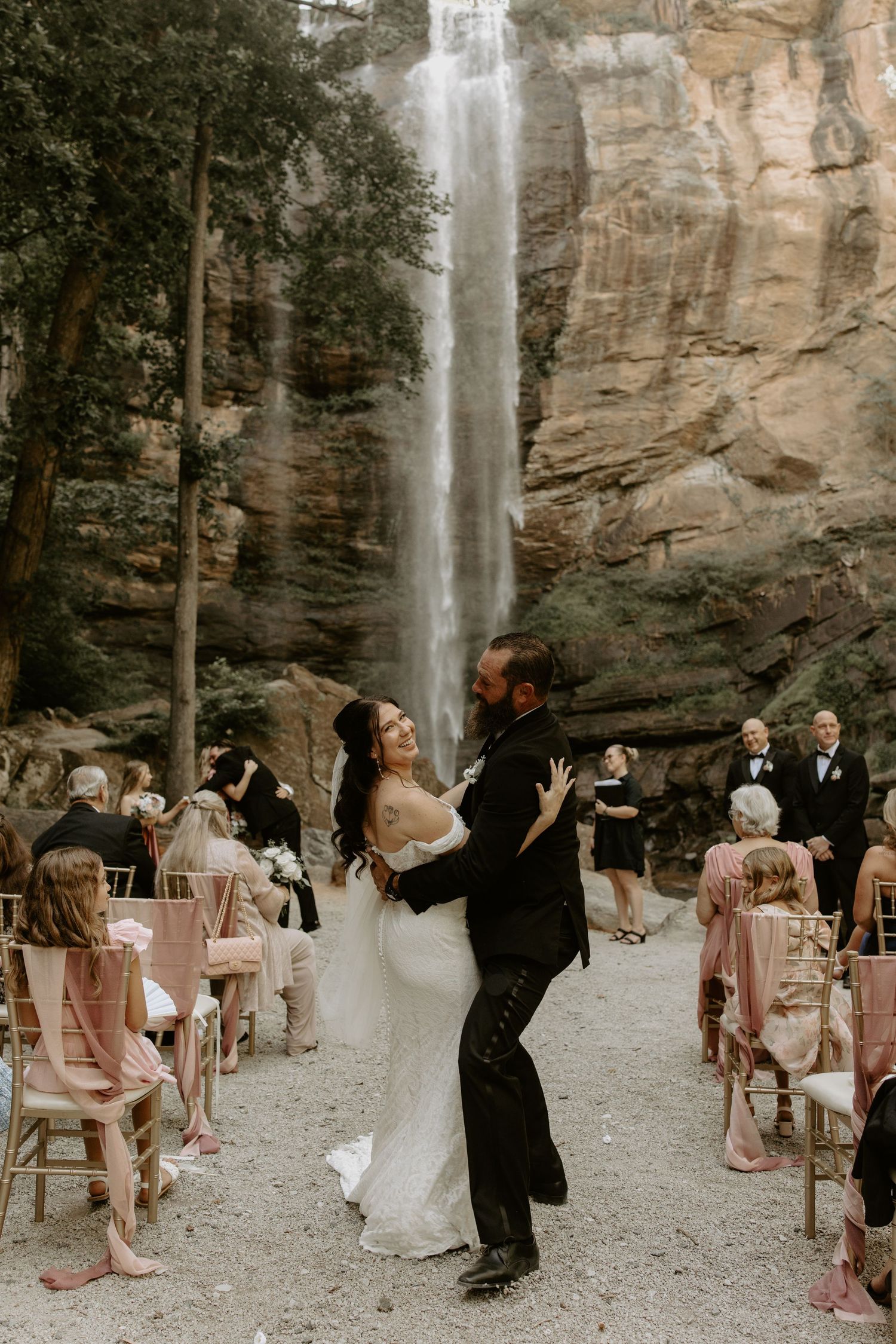 Wedding ceremony with chairs set up in front of a majestic waterfall at Toccoa Falls creates a stunning natural backdrop.