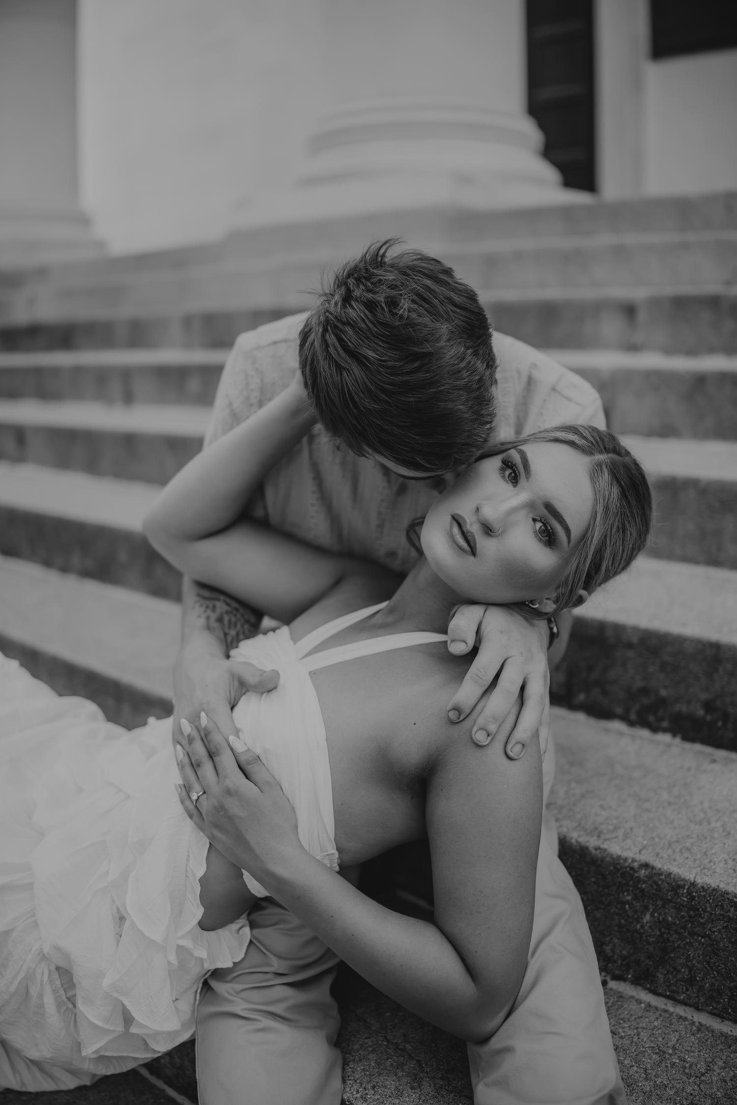 A black and white artistic photo series showing a person laying down on concrete steps in contemplative poses.