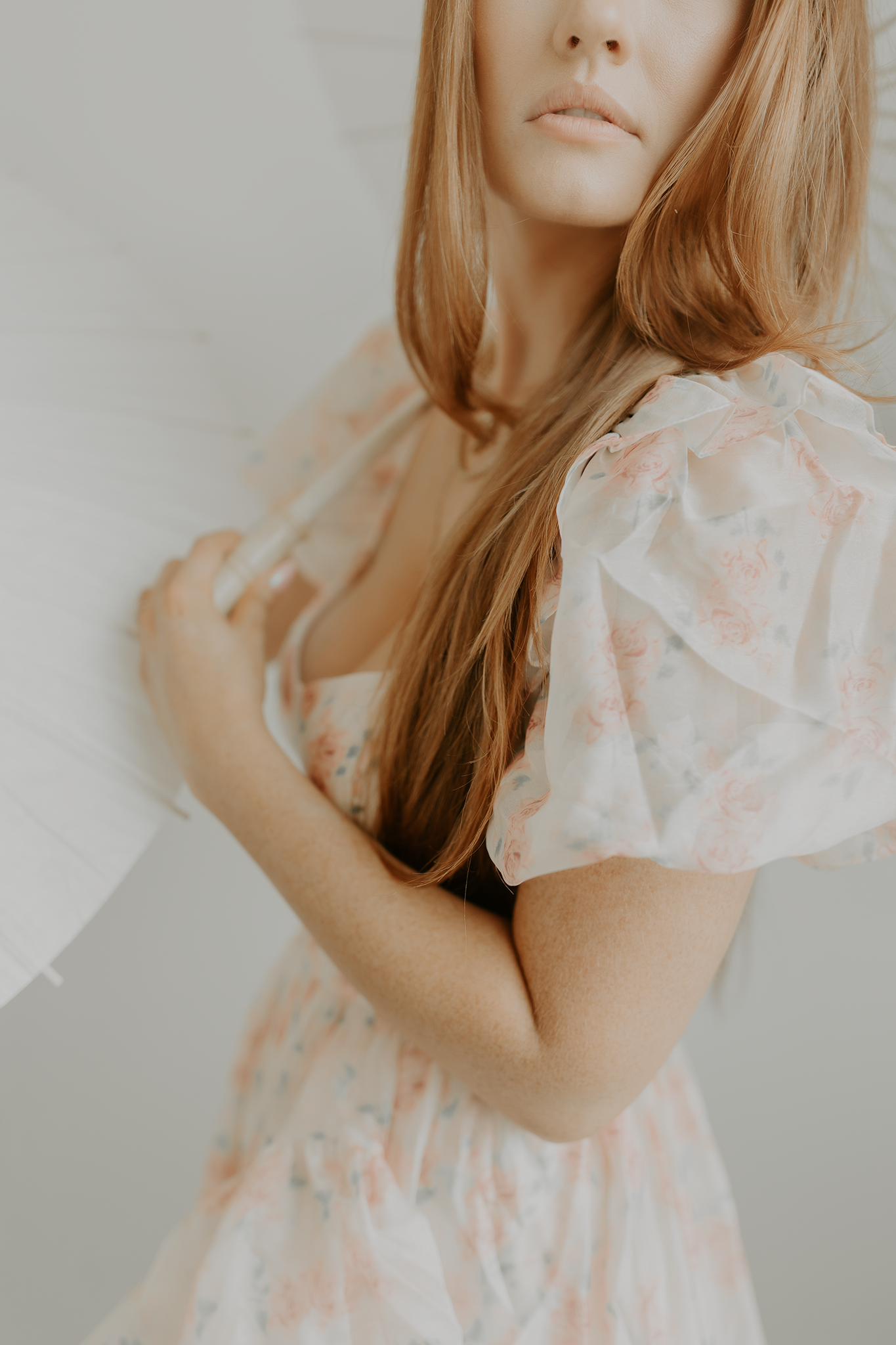 Dreamy portrait of woman in floral dress with soft peachy tones.