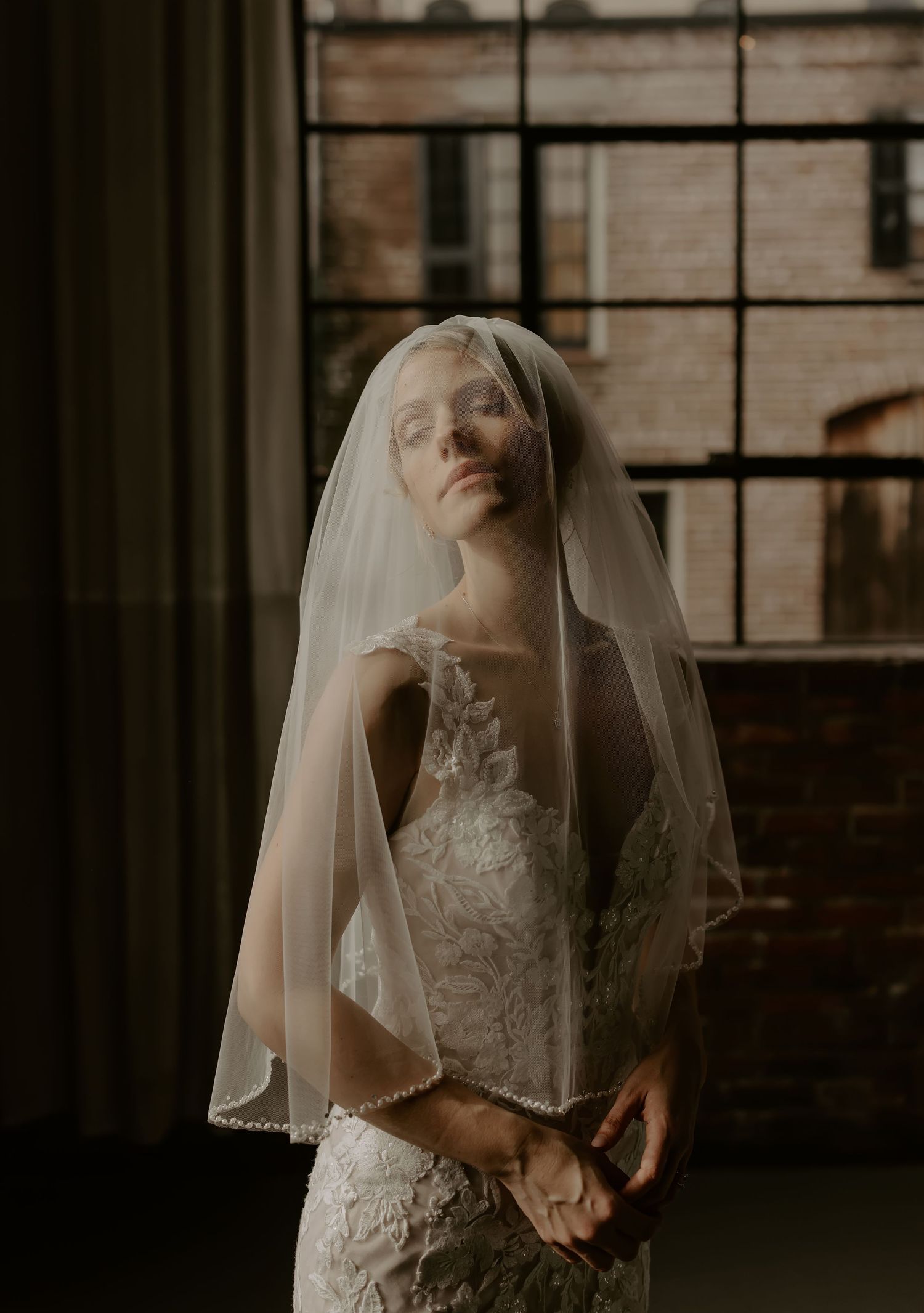 A romantic series of bridal portraits showing a woman in a white lace wedding dress and veil in moody lighting.