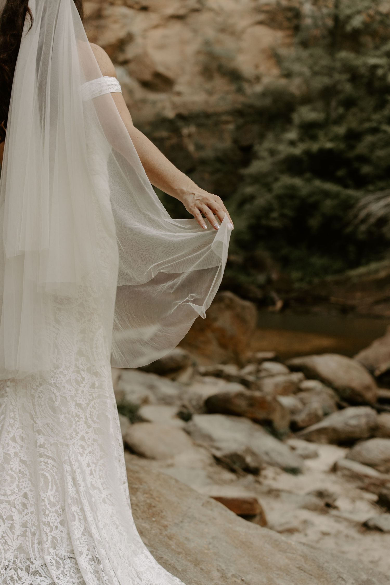 White lace wedding dress train flows across rocky terrain in a series of artistic detail shots.