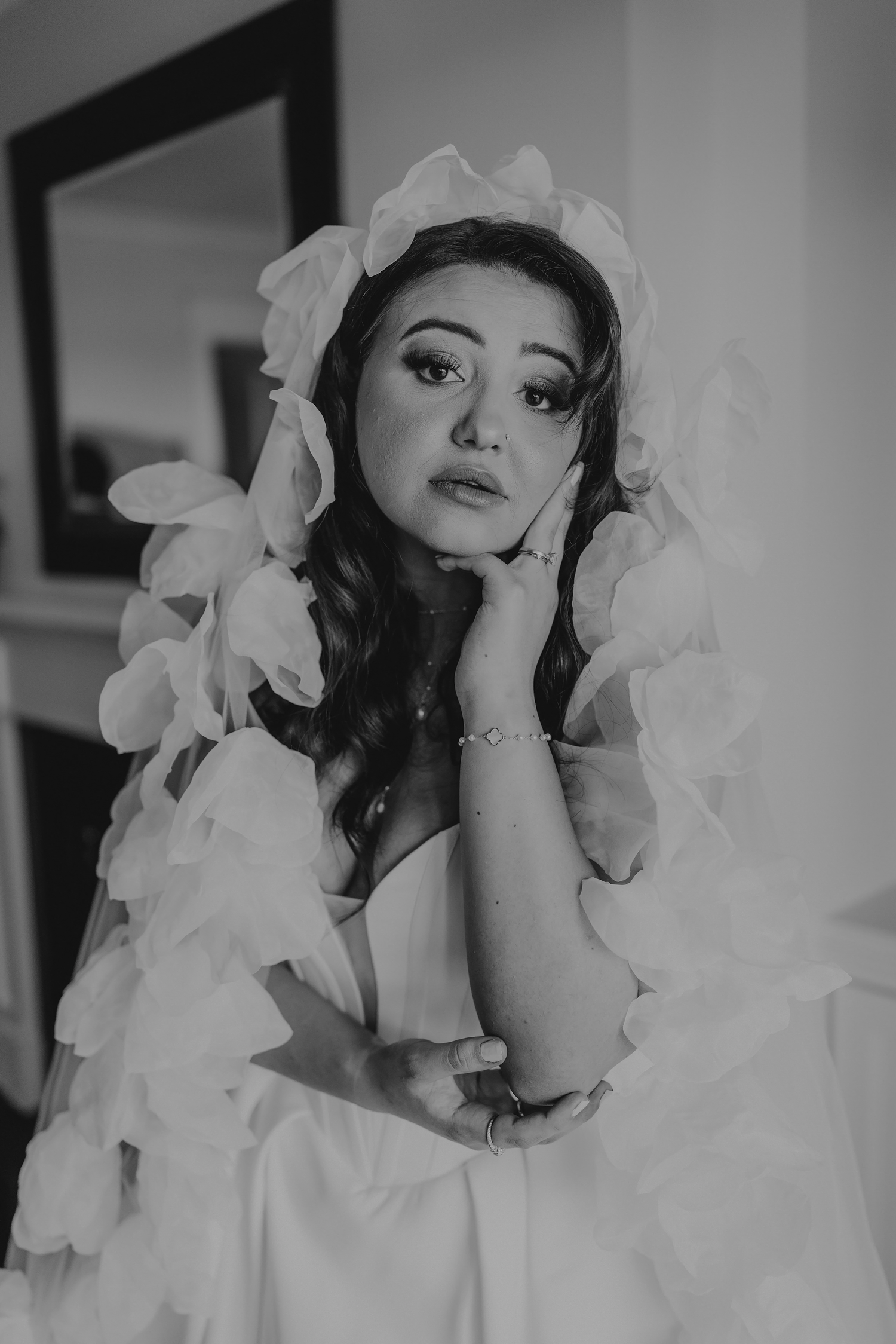 Portrait of bride in white ruffled dress with dramatic lighting.