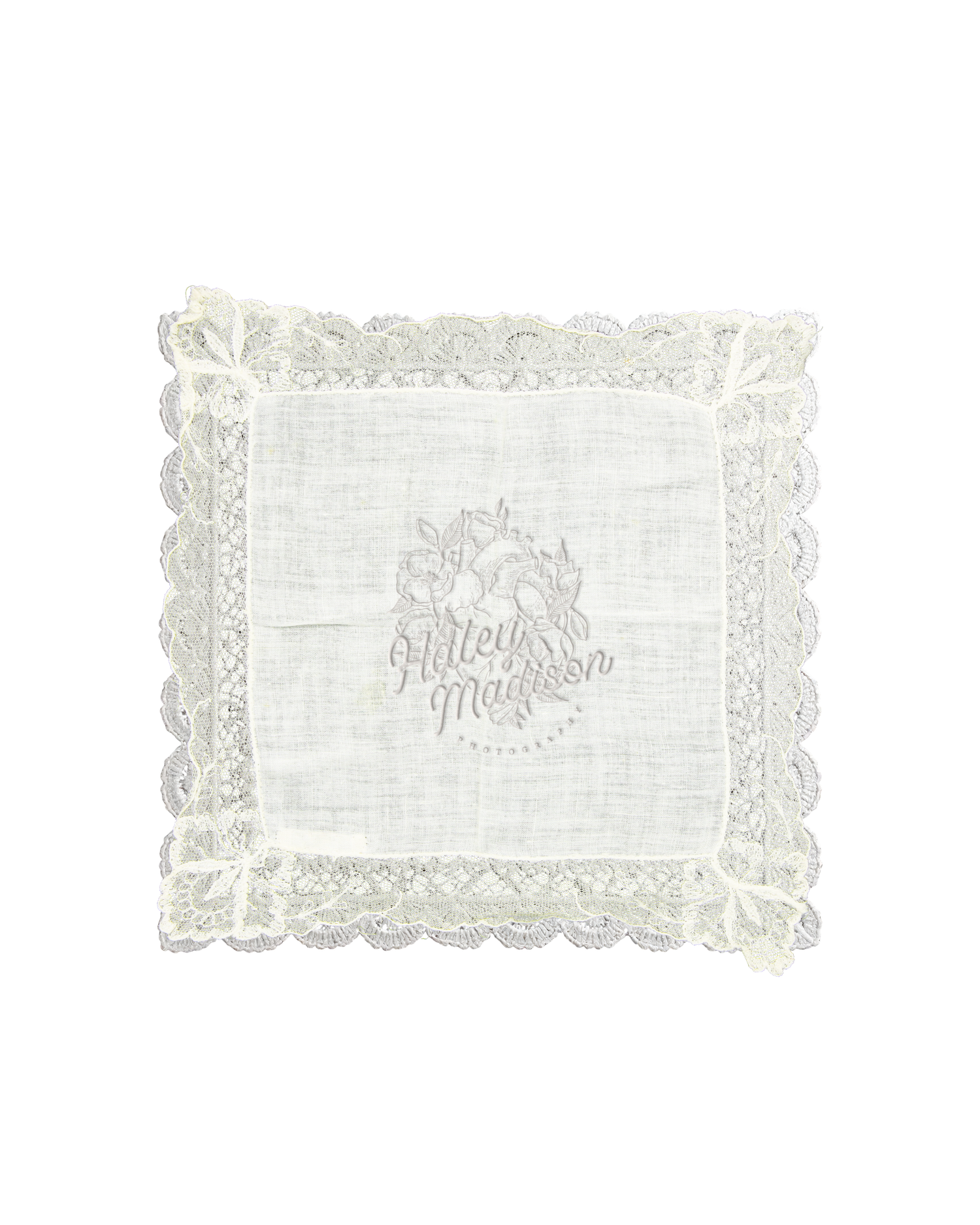 White lace-trimmed handkerchief with delicate embroidered floral monogram design, elegant vintage-style fabric square.