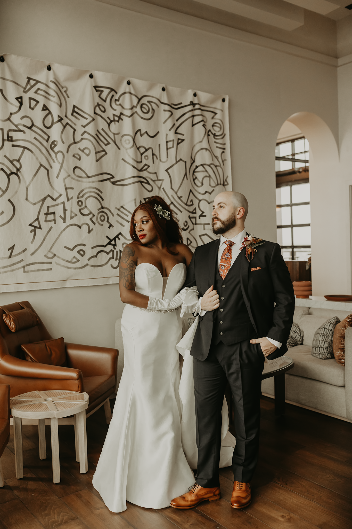A series of candid wedding moments showing a couple laughing and interacting in front of a wall with abstract art designs.