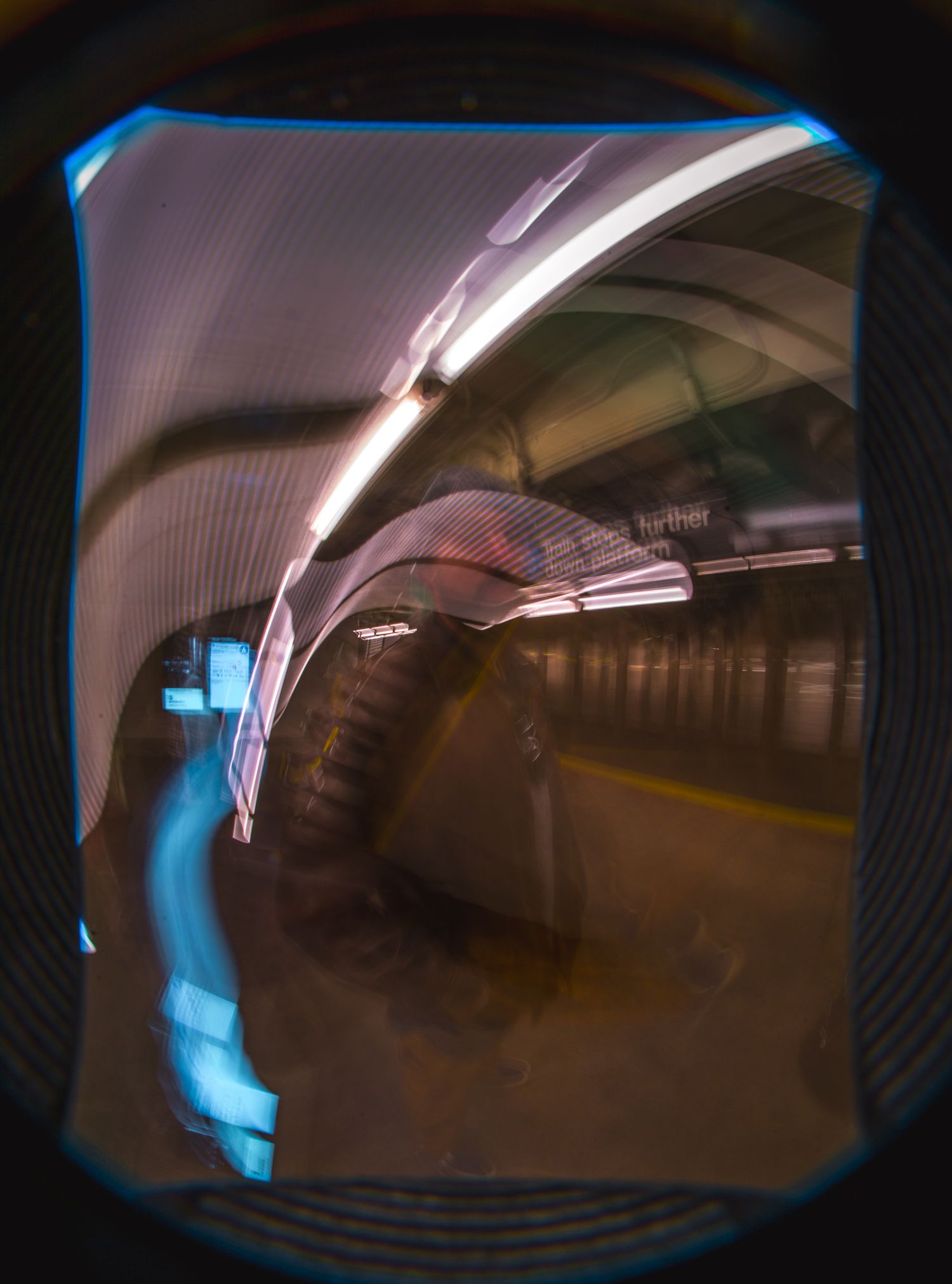 Blurred motion photography captures dark subway tunnel with blue lighting effects.