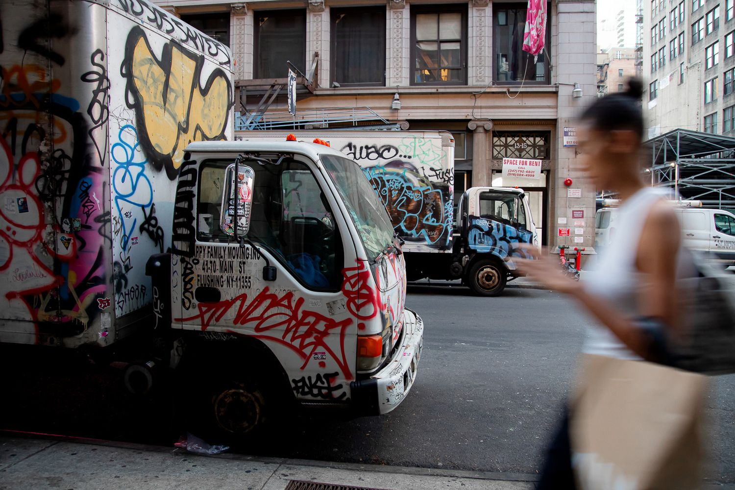 Urban street scene with graffiti covered walls and buildings in black and white.