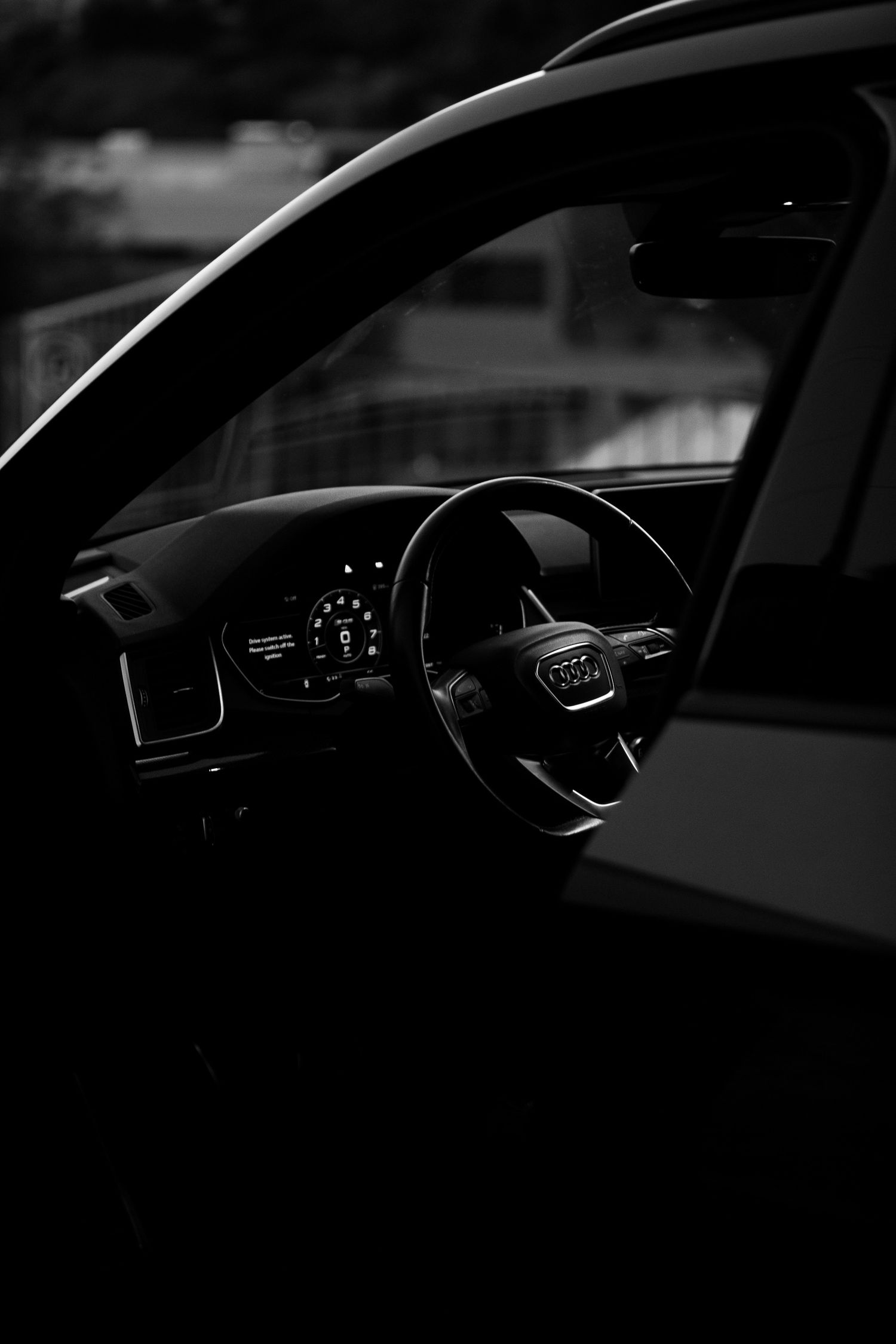 Silhouetted dashboard and steering wheel view inside a modern vehicle cabin.