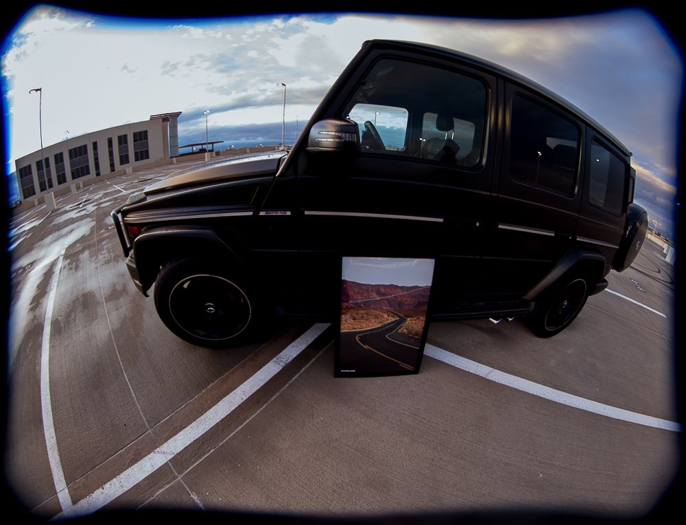 Low angle fisheye view of black vehicles in a parking lot.