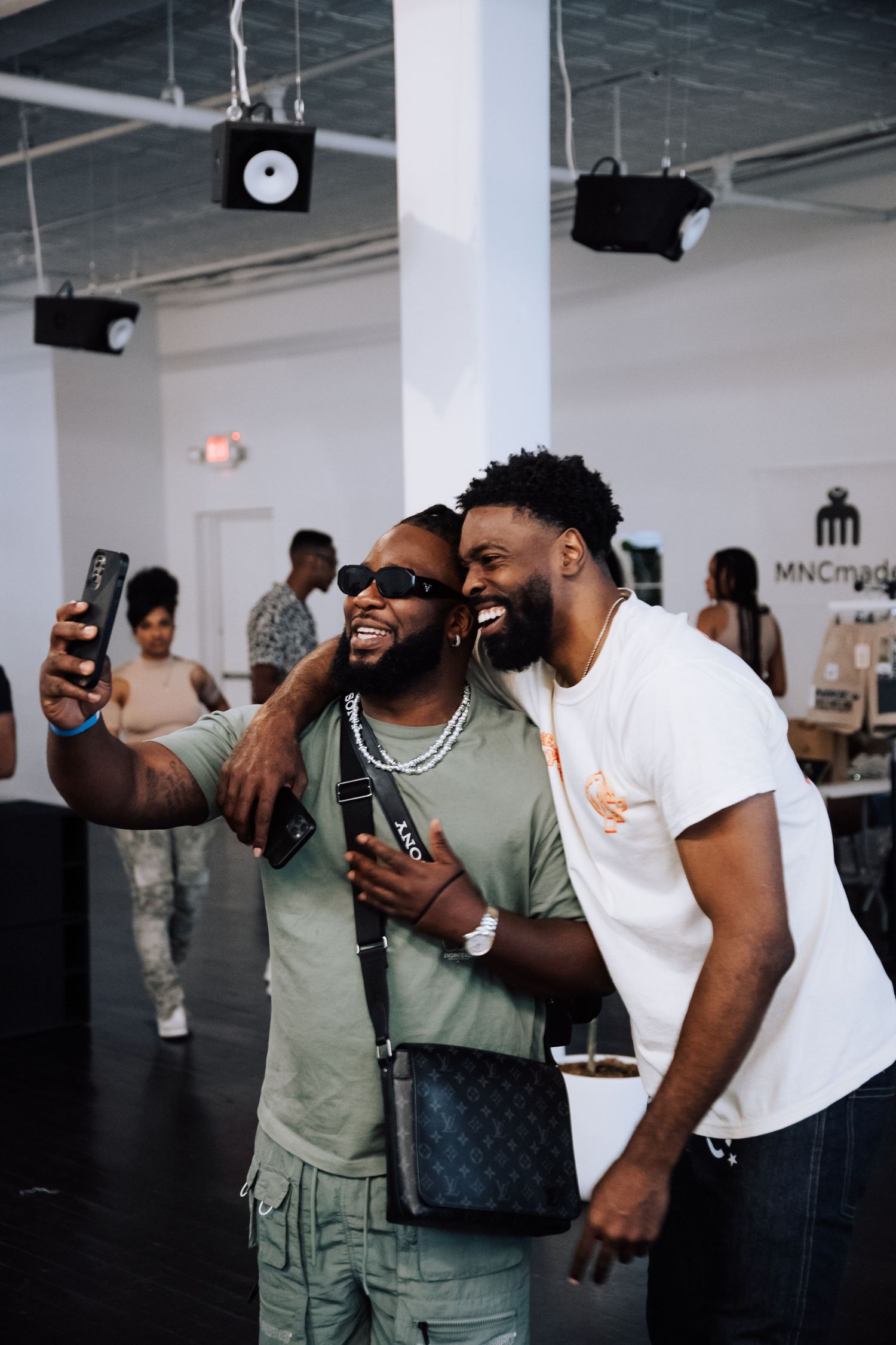 Two friends sharing a joyful moment while taking a selfie together in an indoor space.