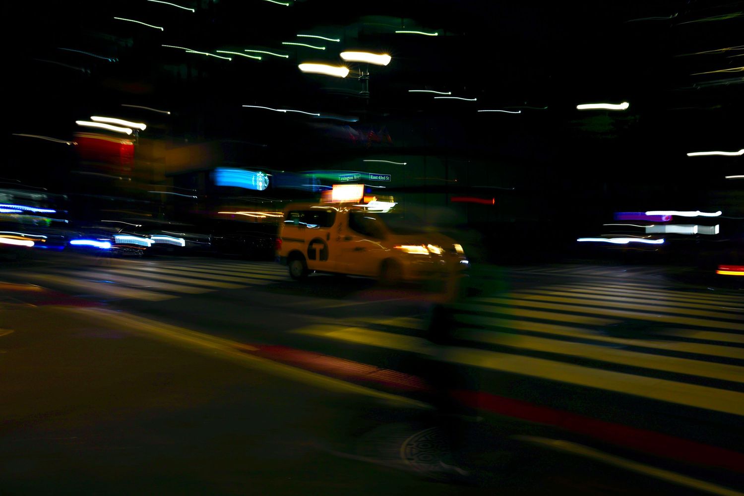 Abstract motion blur of colorful lights streaking across a dark background.