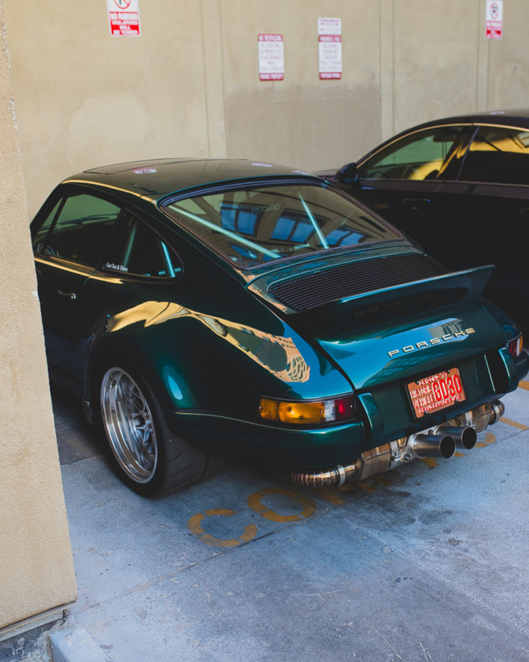 Classic Porsche 911 in metallic green with custom wheels parked in an alleyway. Phoenix, AZ.