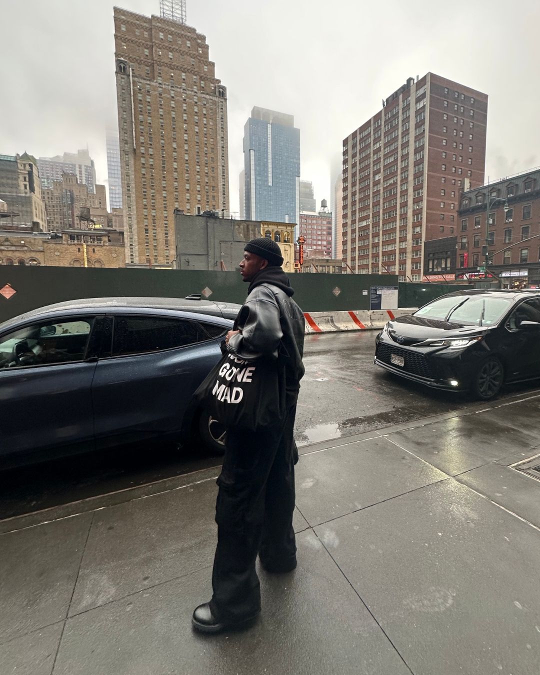 Urban street view with fashionable person posed against cityscape backdrop. New York City.