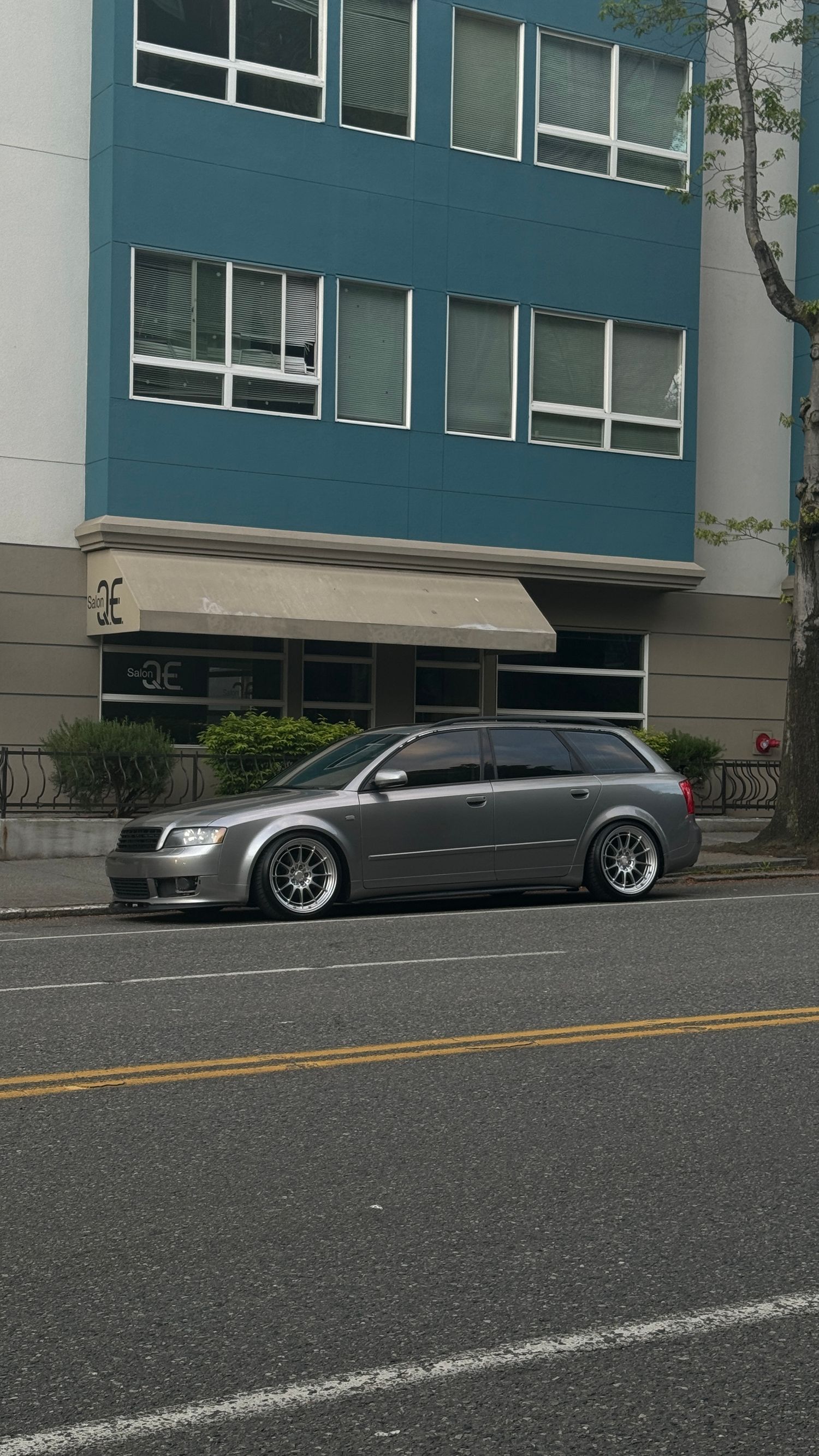 Lowered Audi wagon with custom wheels parked in front of modern office building. Seattle, WA.