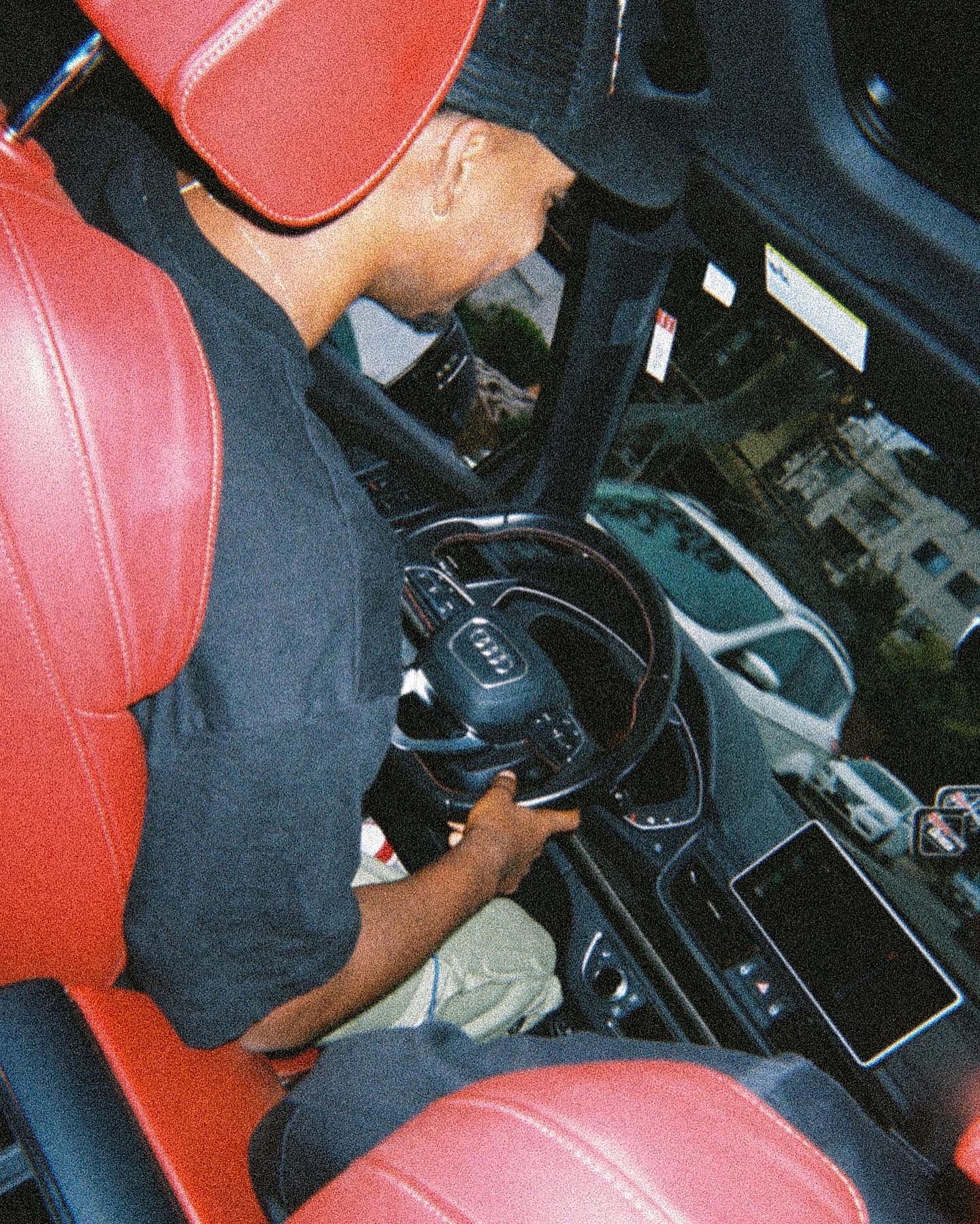 Red leather interior car seats shown in dark lighting conditions.