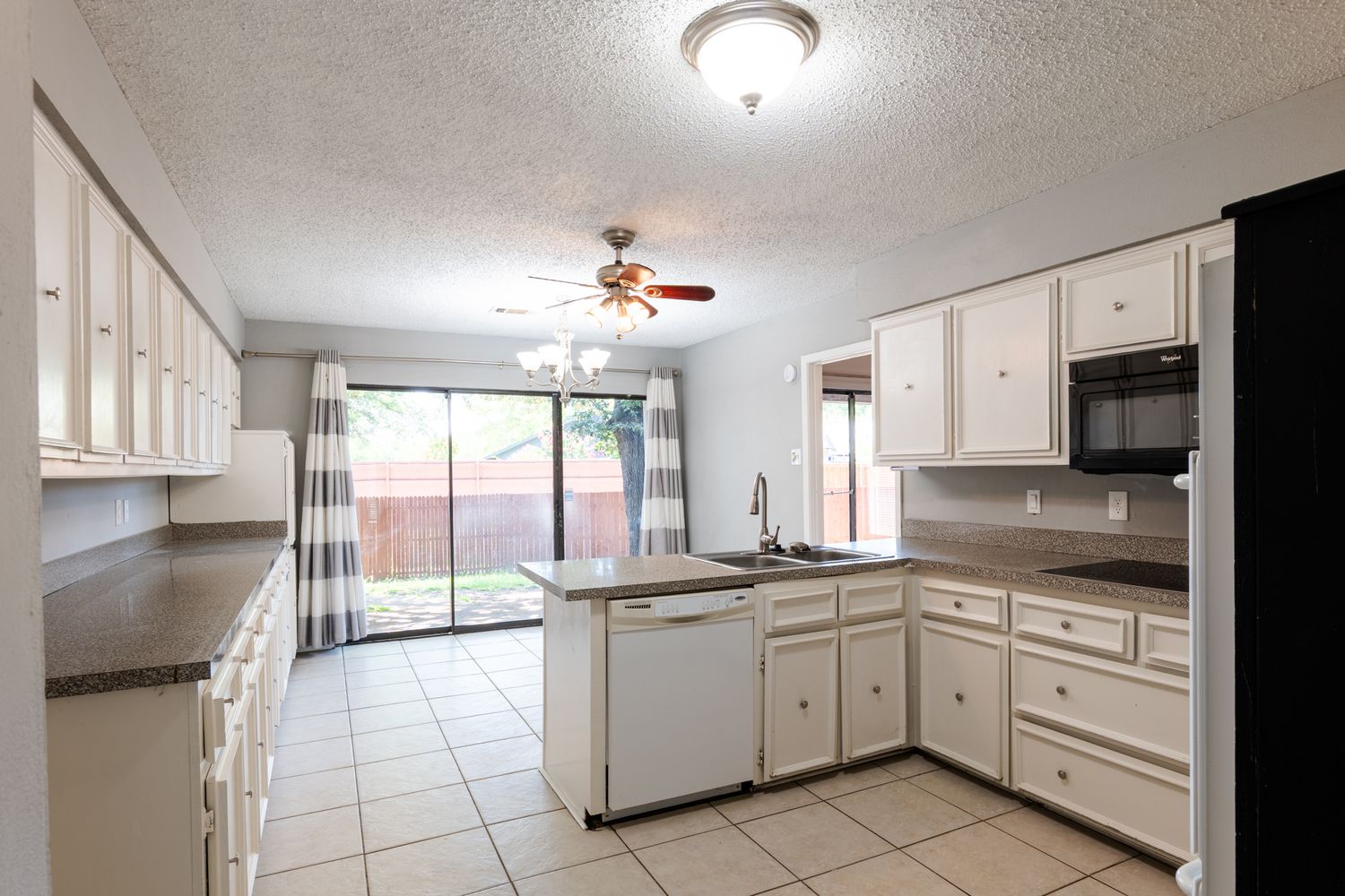 Long galley kitchen with white cabinets and bright lighting shown from different perspectives.