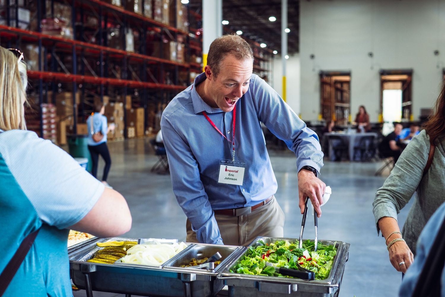 Workers preparing food in a commercial kitchen or warehouse setting.