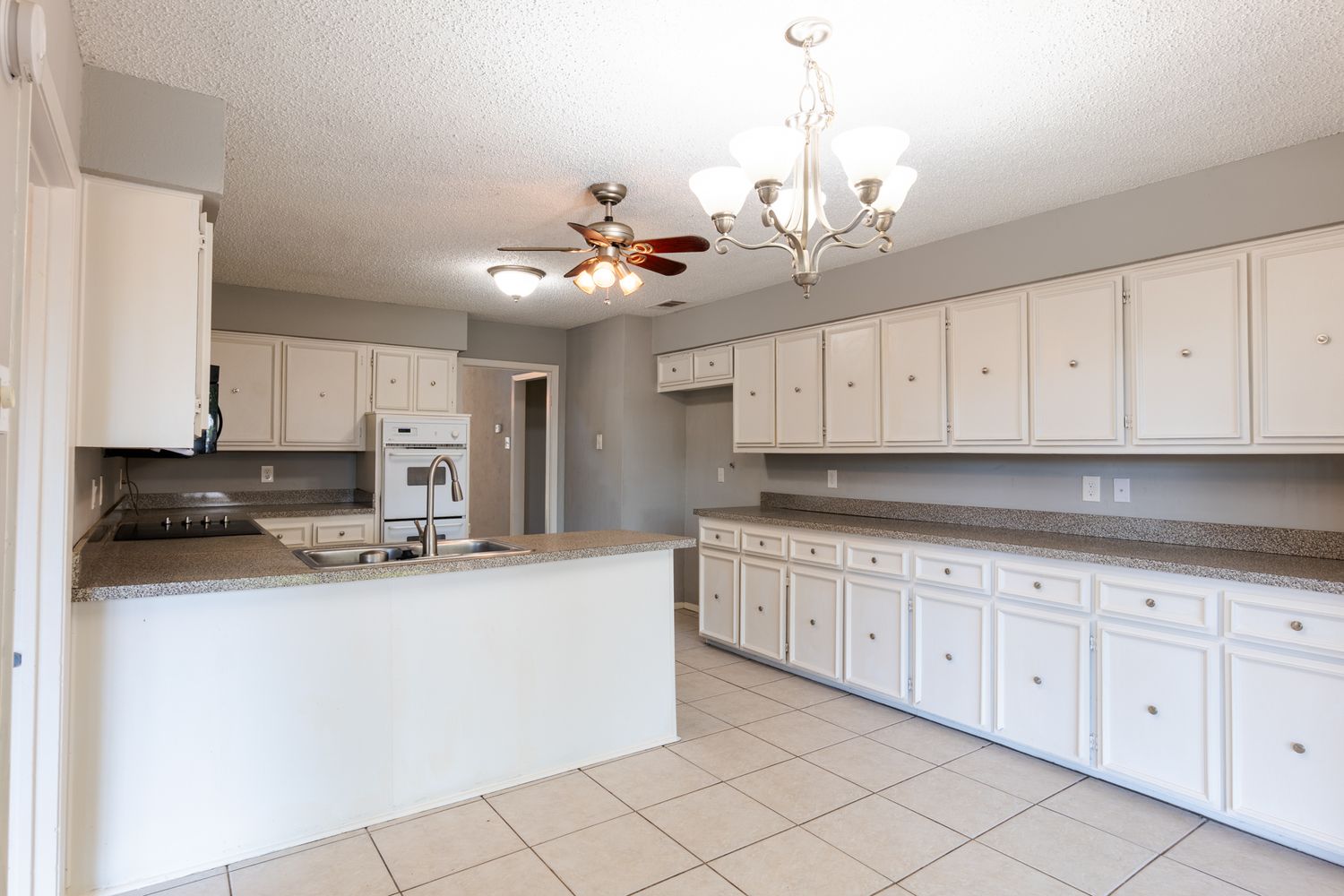 White kitchen with recessed lighting and tile flooring viewed from multiple angles.
