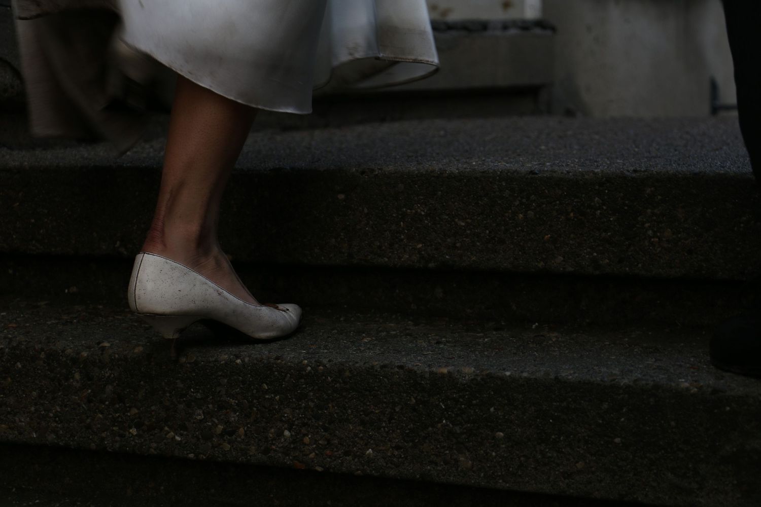 Couple dancing together during their wedding celebration on a brick pathway.