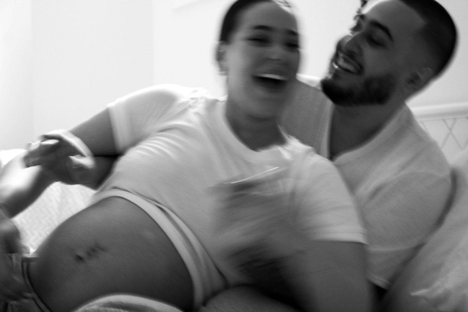 A black and white photo captures a couple's genuine laughter and embrace.