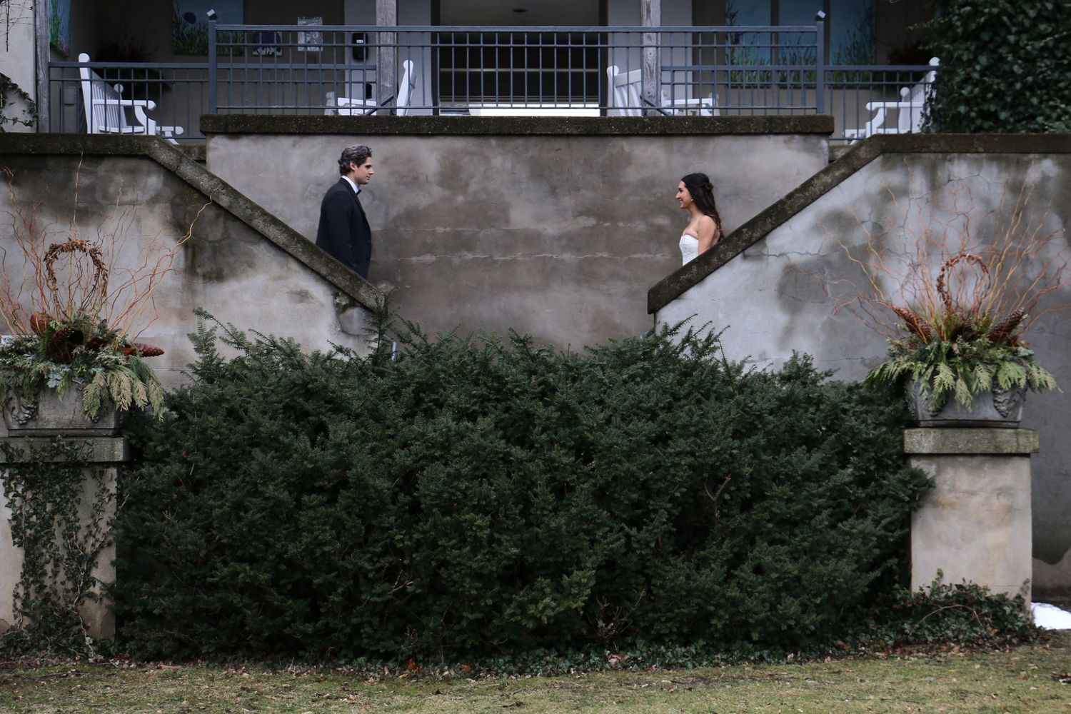 Artistic wedding photo on stone stairs with greenery and plants.