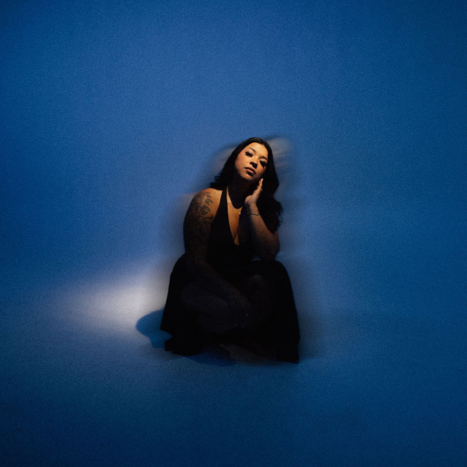 A woman with a blue backfrop in a studio
