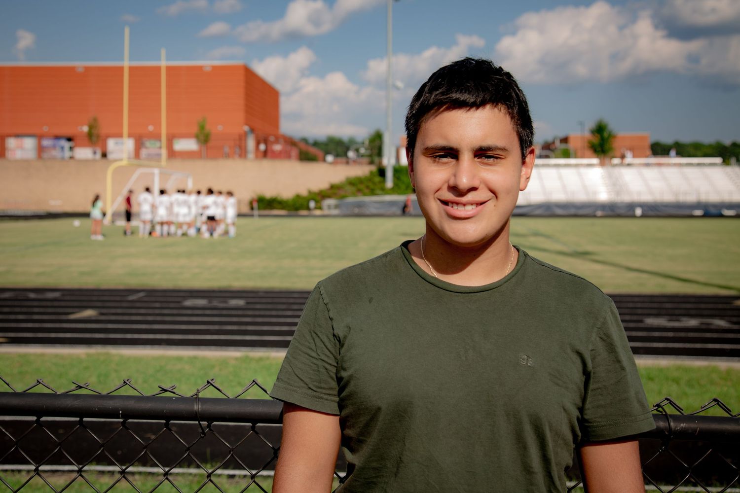 High school student standing confidently at school — graduation-style portrait in natural light.