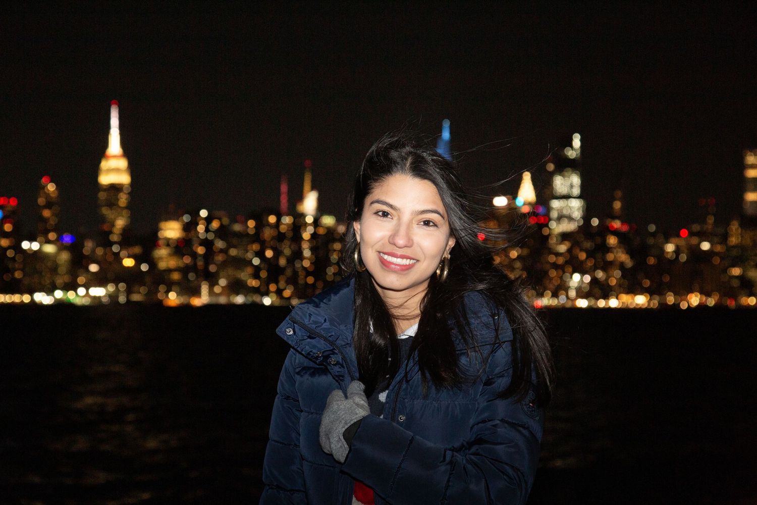 Teen girl posing with New York City skyline in the background — urban portrait session.