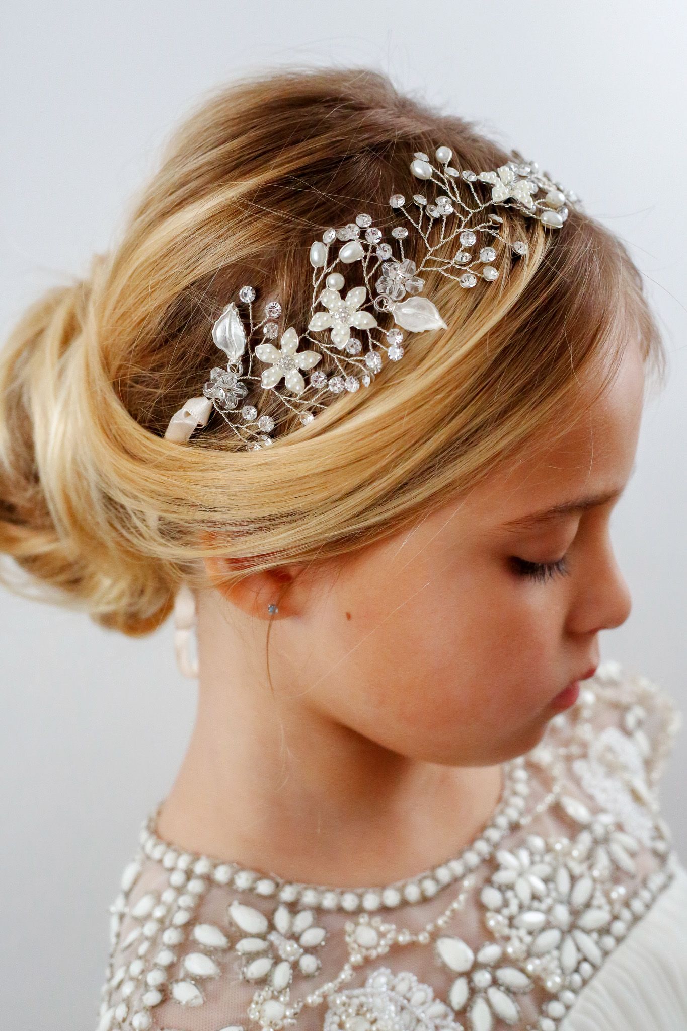 Flower girl smiling during a wedding celebration in Raleigh, captured with natural light and soft tones.