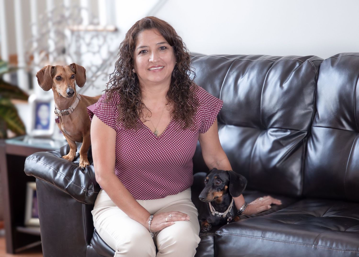 Smiling woman with her two dogs during a relaxed outdoor session — lifestyle and pet photography.