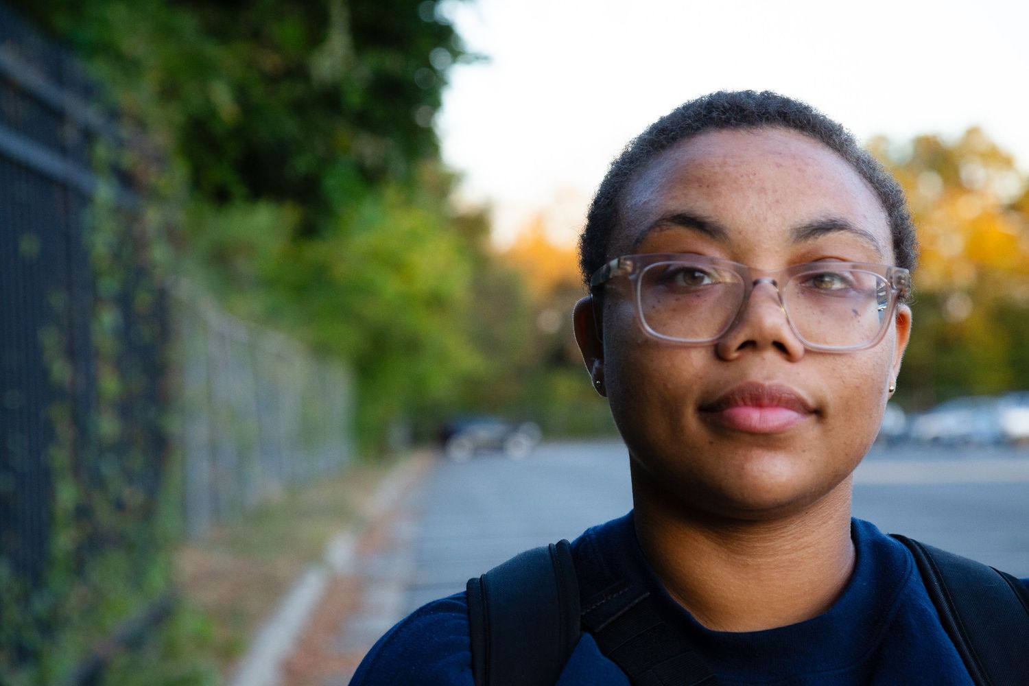 Stylish college student standing in parking lot — modern and spontaneous campus portrait.”