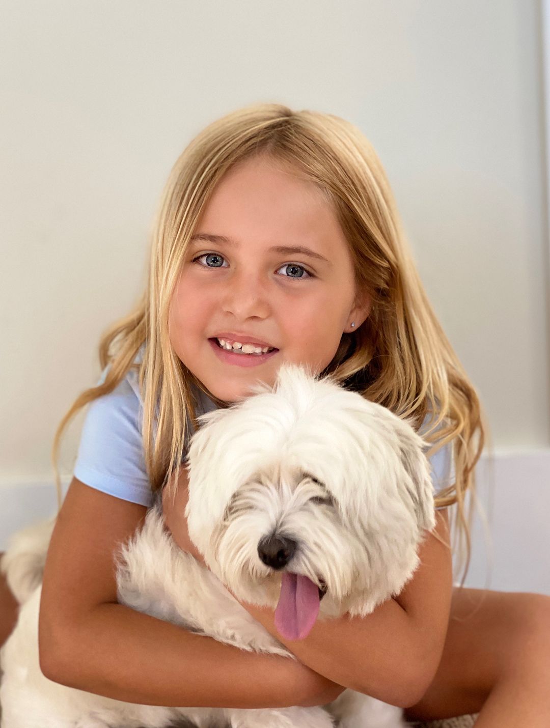 Sweet moment of a young girl hugging her dog during a relaxed outdoor photo session in Chapel Hill.