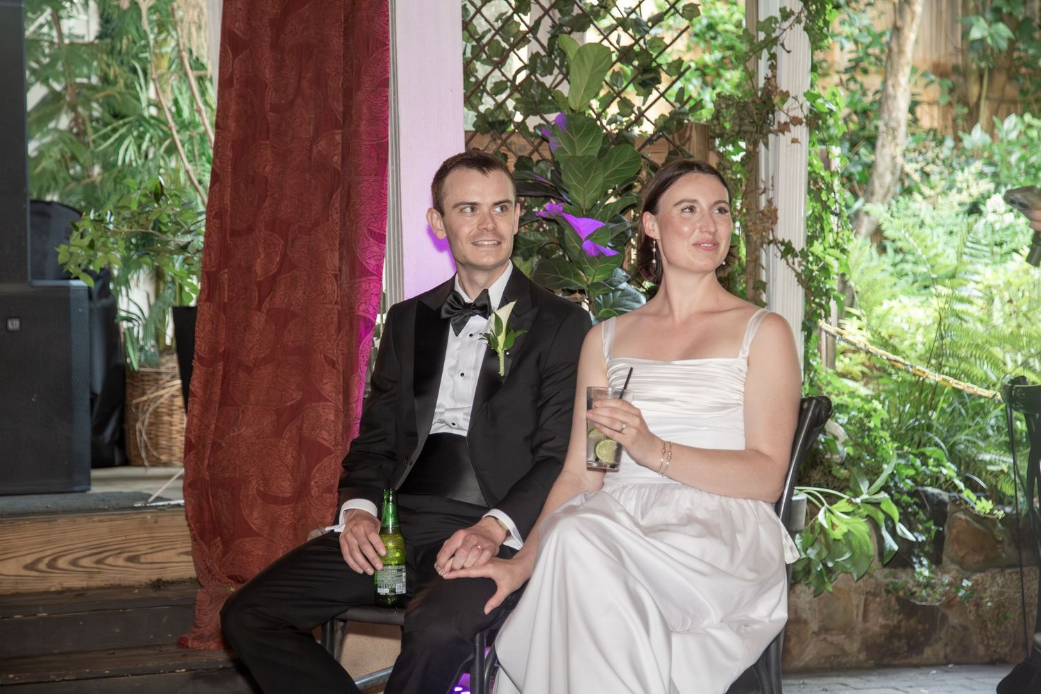 Bride and groom smiling while hearing touching words from their best friends.