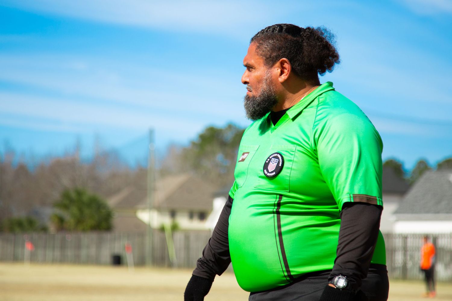Line referee on the soccer field focused during an active match.