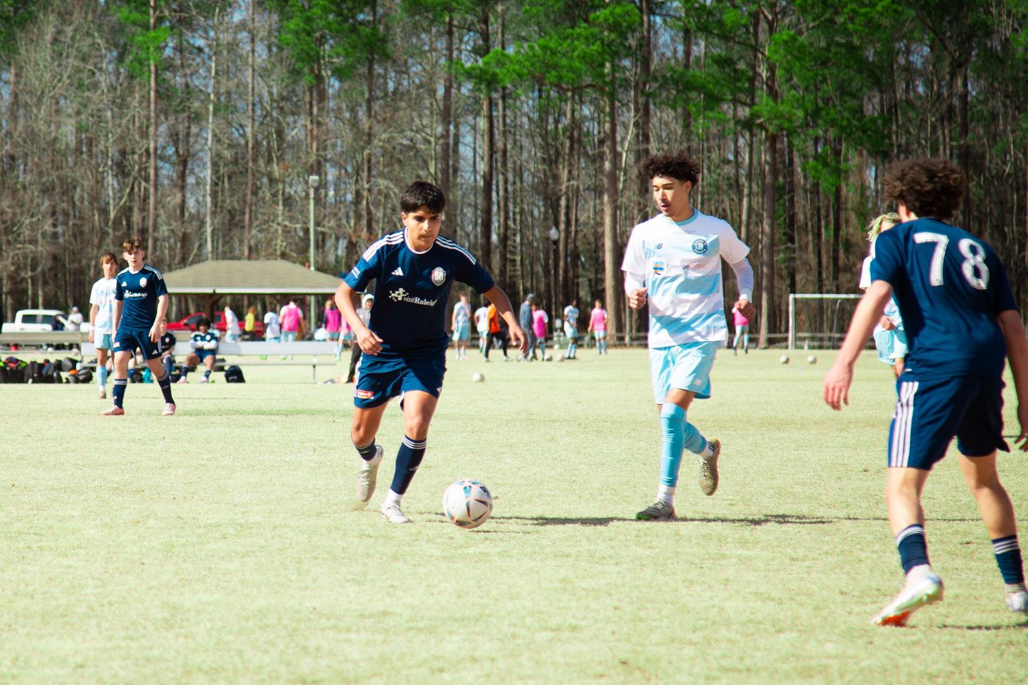 Soccer player in control of the ball while dribbling — focused sports photography capturing skill.