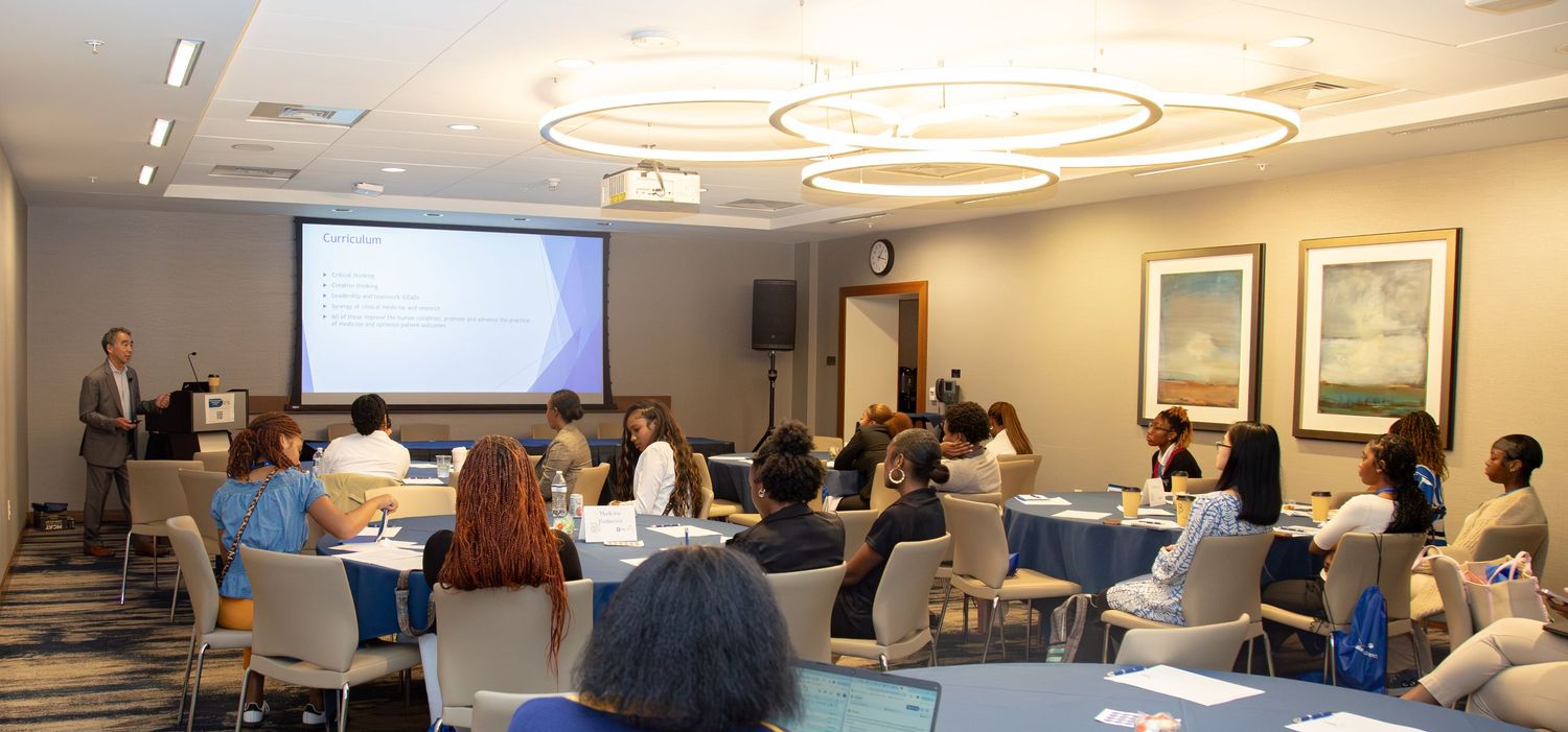 Wide view of a filled conference room with an engaged audience attending a live presentation in Durham.
