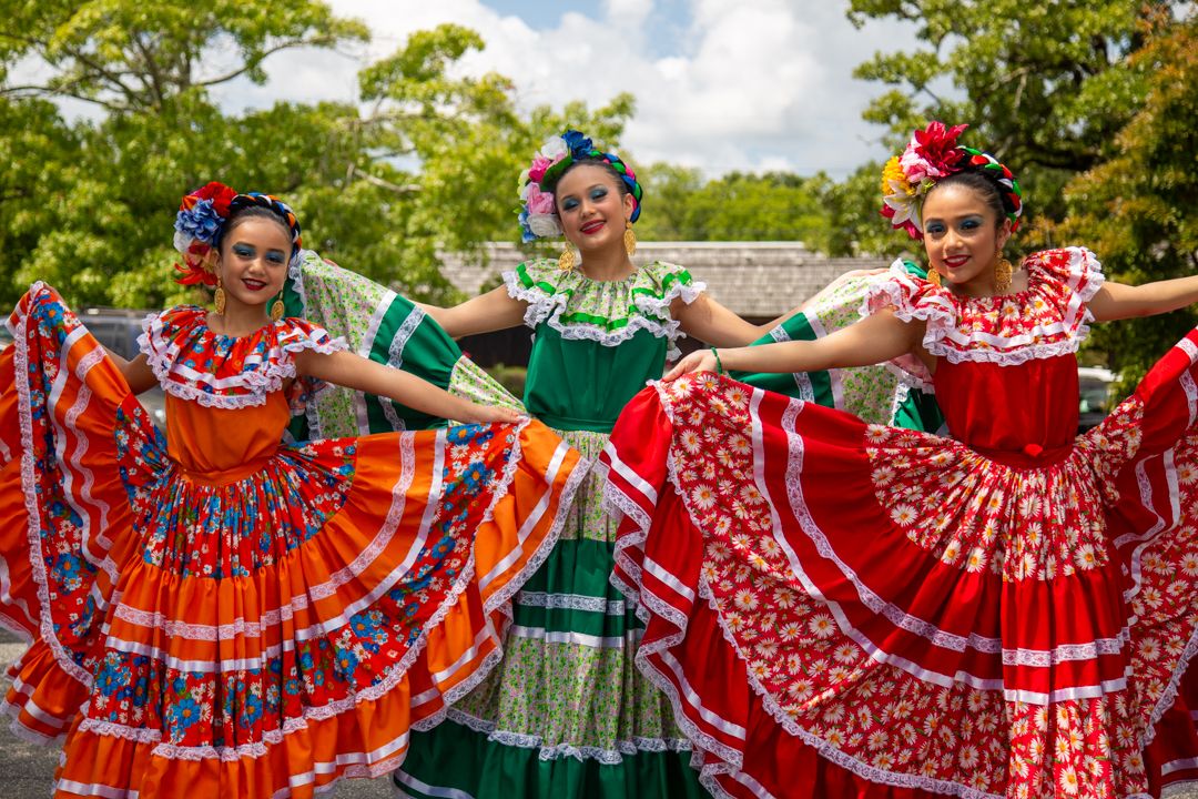 Tres niñas con trajes típicos tradicionales en una celebración cultural en Chapel Hill