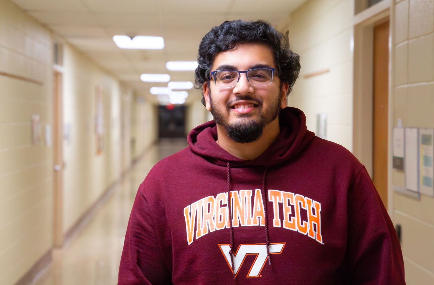 College student standing outside classroom building — natural light portrait on campus.