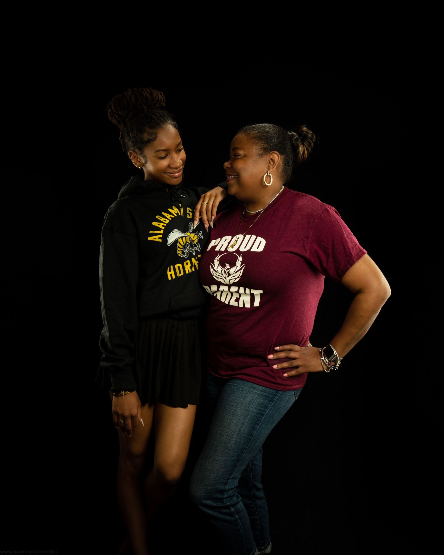 Two women smiling and posing together, one wearing an Alabama State Hornets shirt and the other a Proud Parent maroon tee.