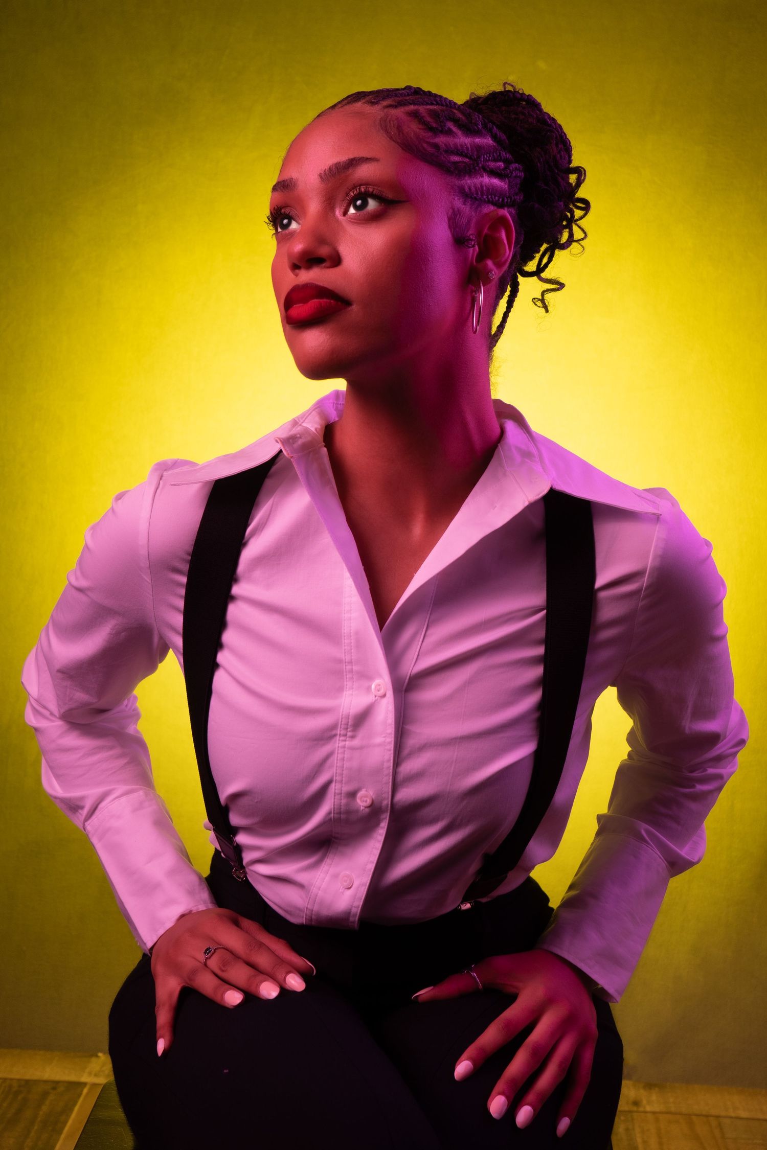 A figure in a white button-down shirt and dark vest poses dramatically against a yellow-lit backdrop in a photo series.