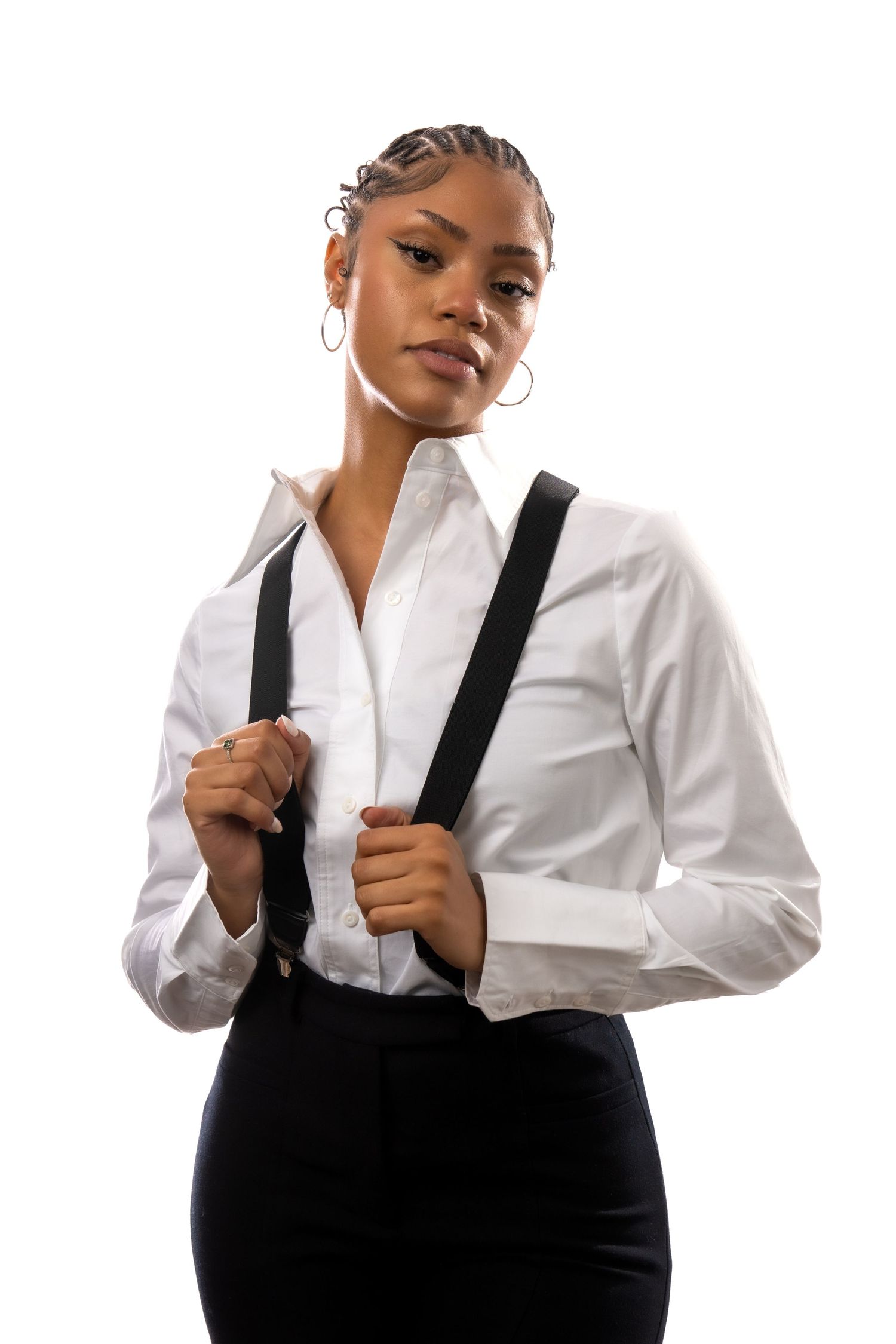 Professional model in classic white button-down shirt and black suspenders poses confidently against white background.