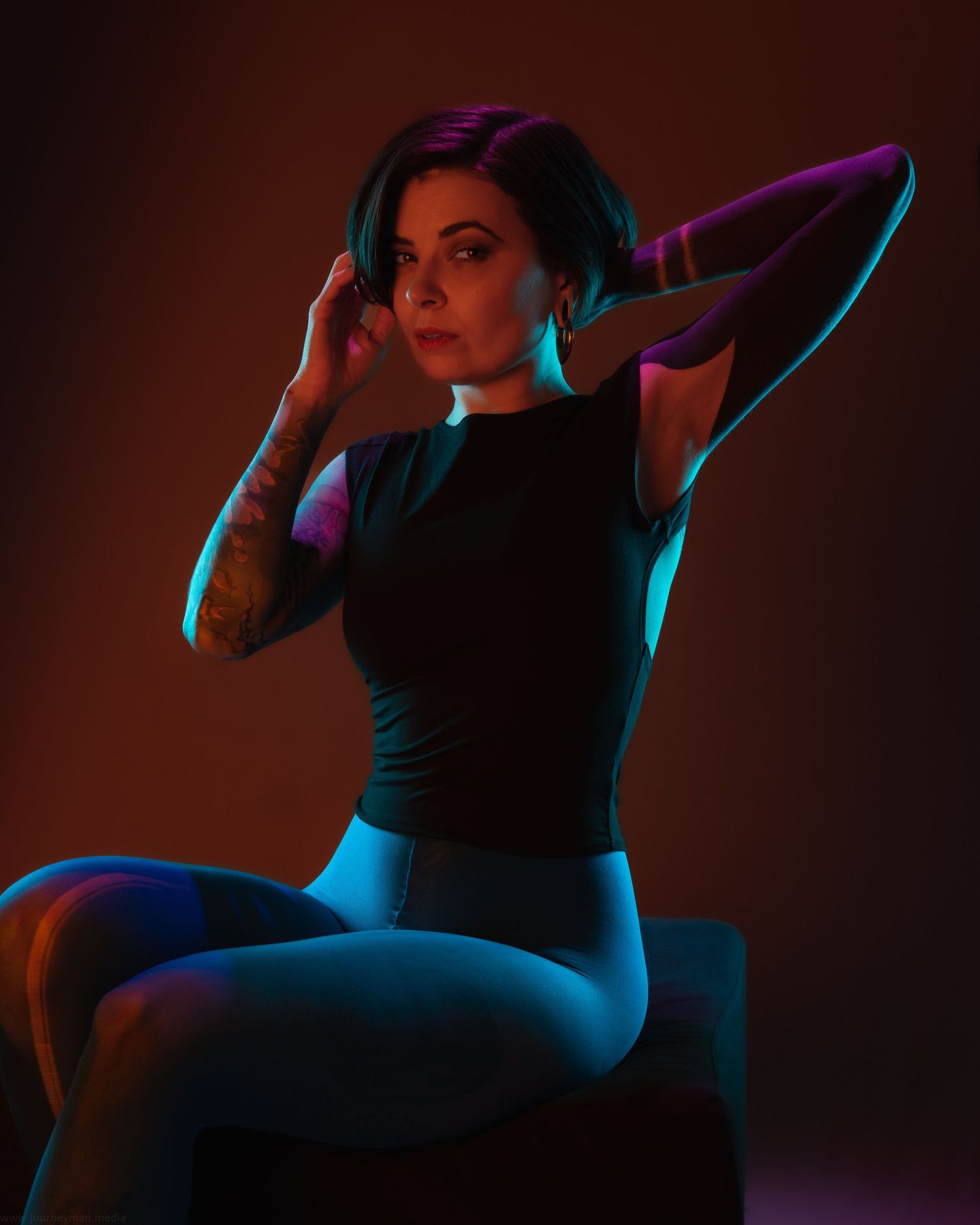 A figure strikes dramatic poses in atmospheric lighting with blue and pink neon accents against a dark background.