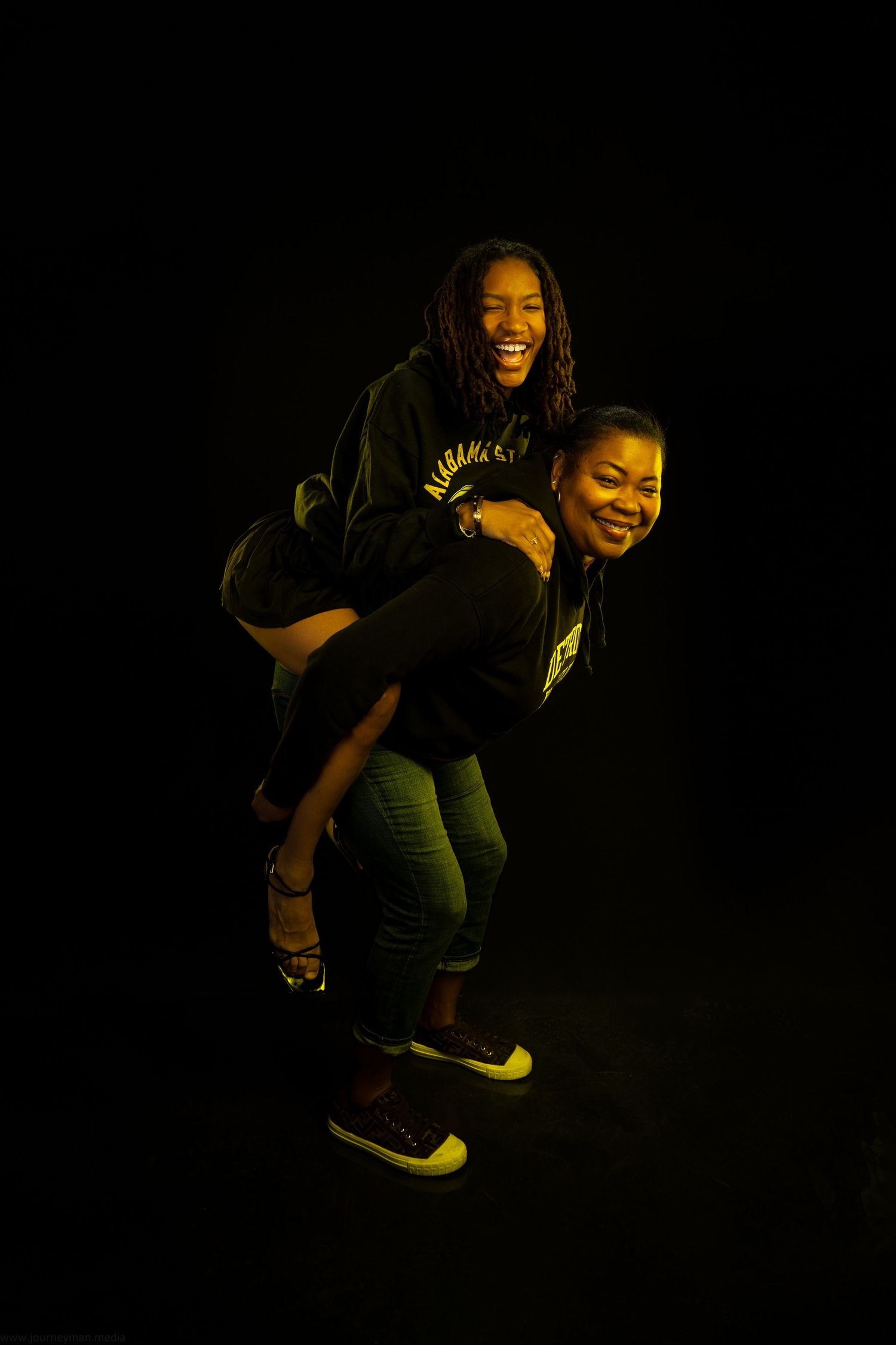 Dark photos show someone in casual attire leaping and laughing joyfully while wearing yellow sneakers against a black background.
