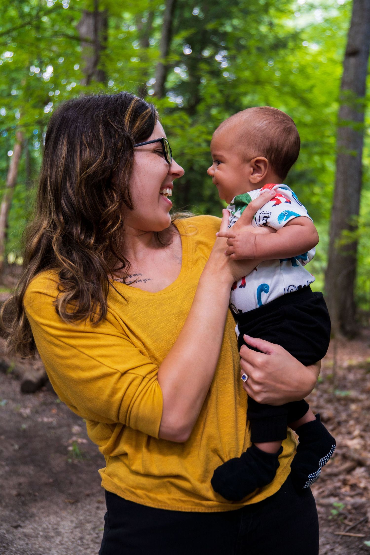 A sequence of joyful candid moments captured between an adult in yellow and a small baby in the woods.