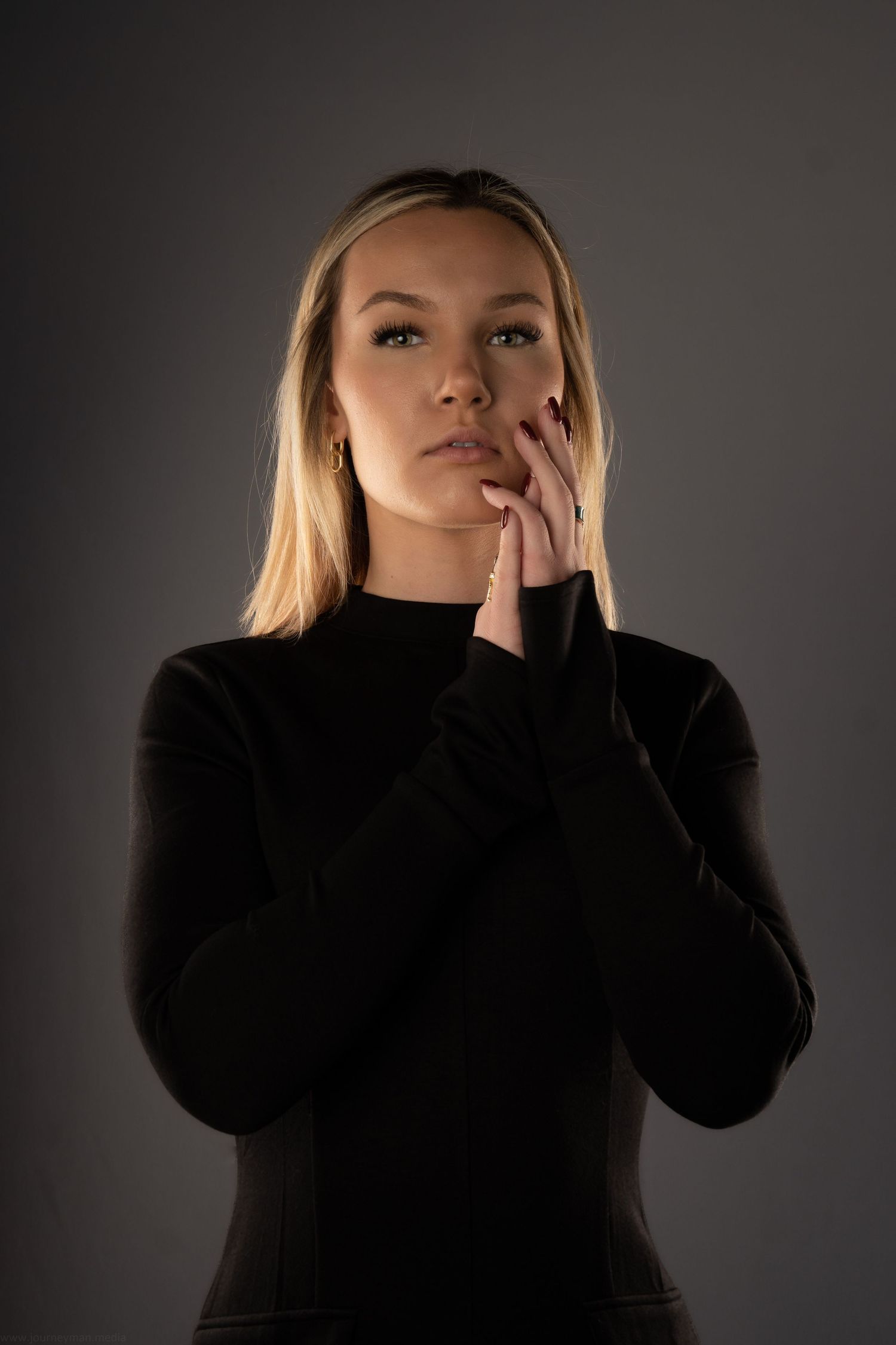 Dramatic portrait series against dark background showing woman in black turtleneck with expressive poses.