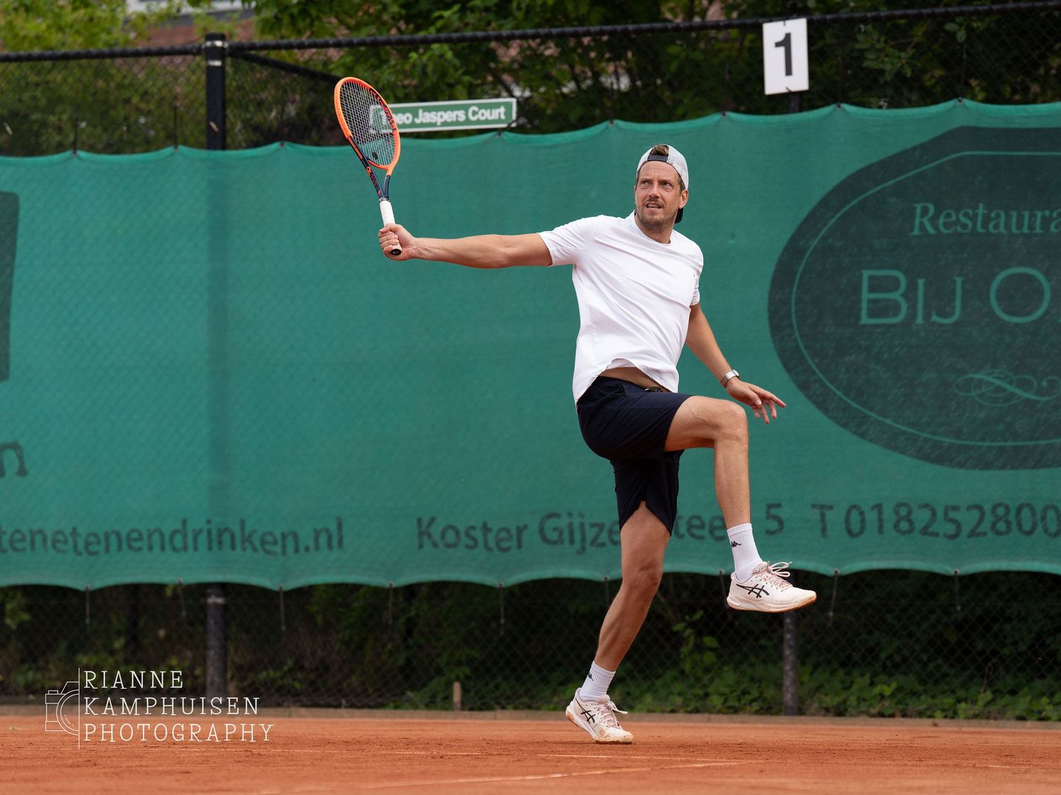 Actiefoto's en finalisten van een gravel tennistoernooi met spelers in actie, dubbelspel, toeschouwers en zomerse sfeer rond de baan.