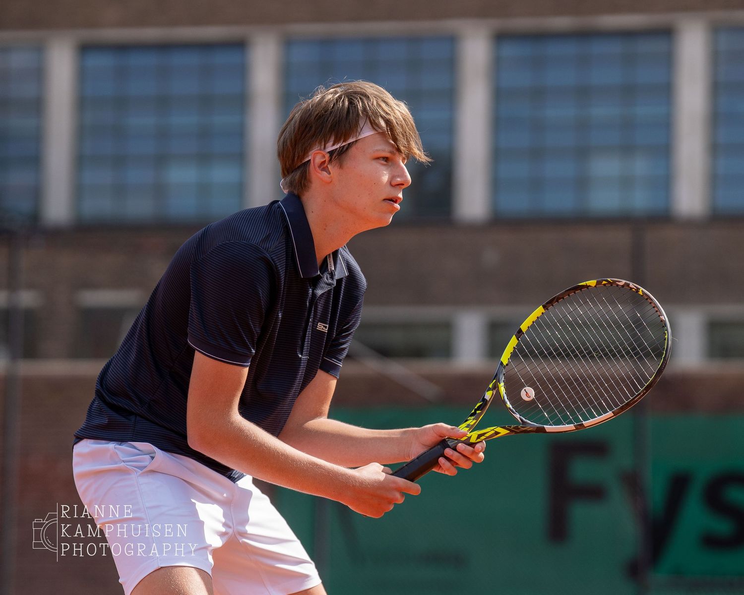 Actiefoto's en finalisten van een gravel tennistoernooi met spelers in actie, dubbelspel, toeschouwers en zomerse sfeer rond de baan.